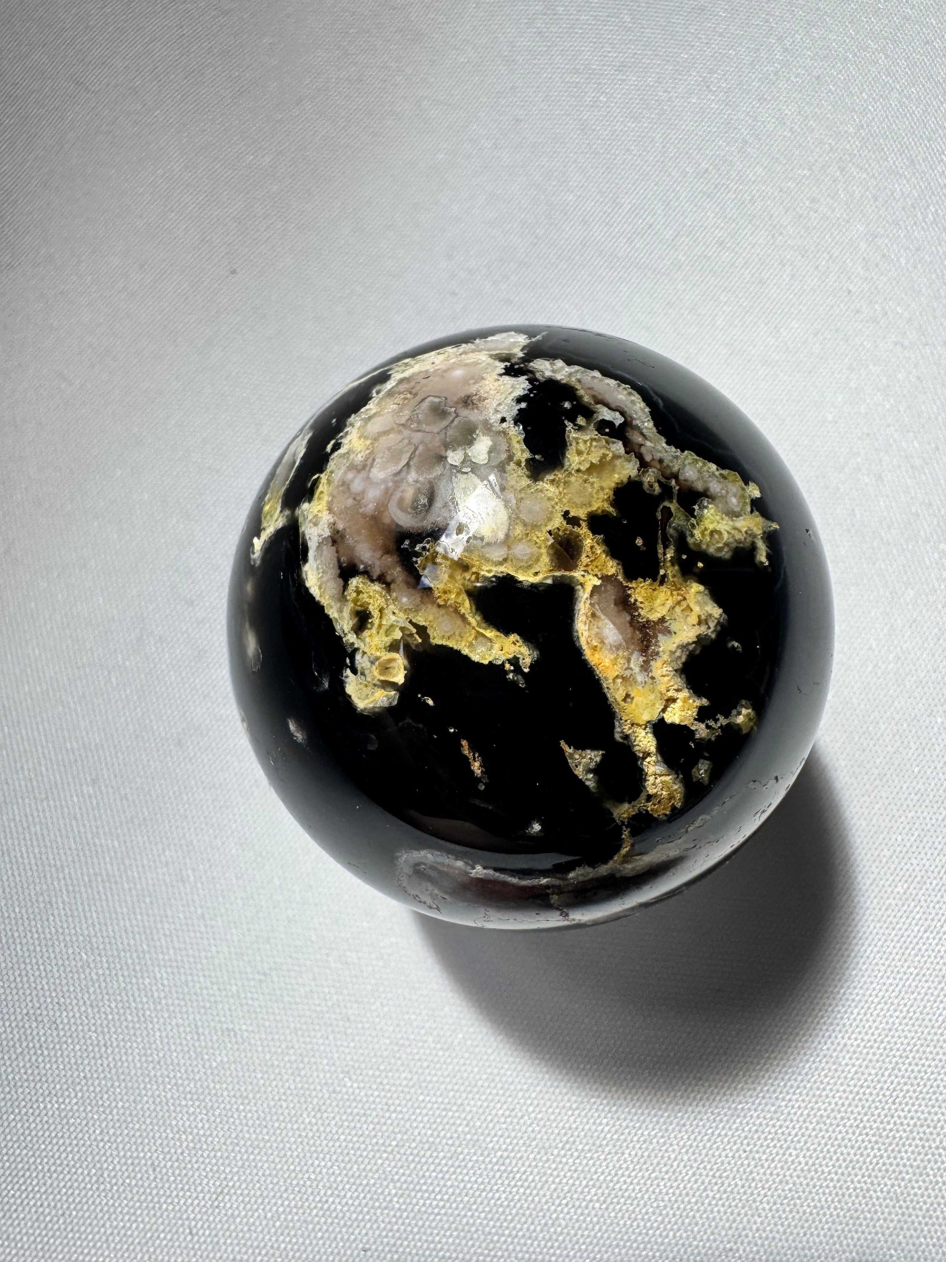 Glossy Black Flower Agate Sphere with intricate yellow and cream mineral formations, enhancing any healing or meditation space | Bespoke Crystals NZ