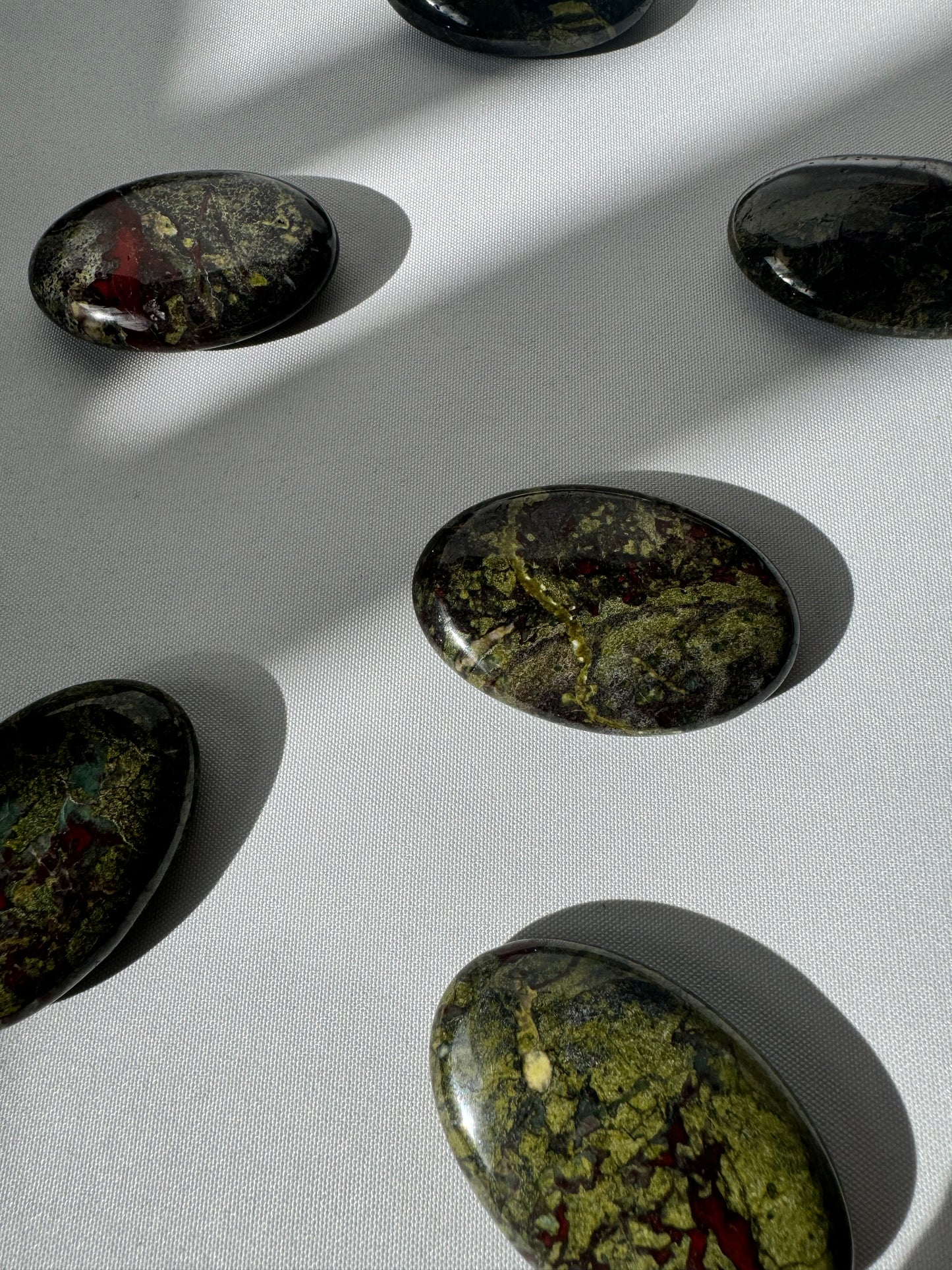 Multiple Dragon Stone Crystal Palm Stones featuring deep earthy tones and striking patterns, perfect for crystal healing and rock collections.