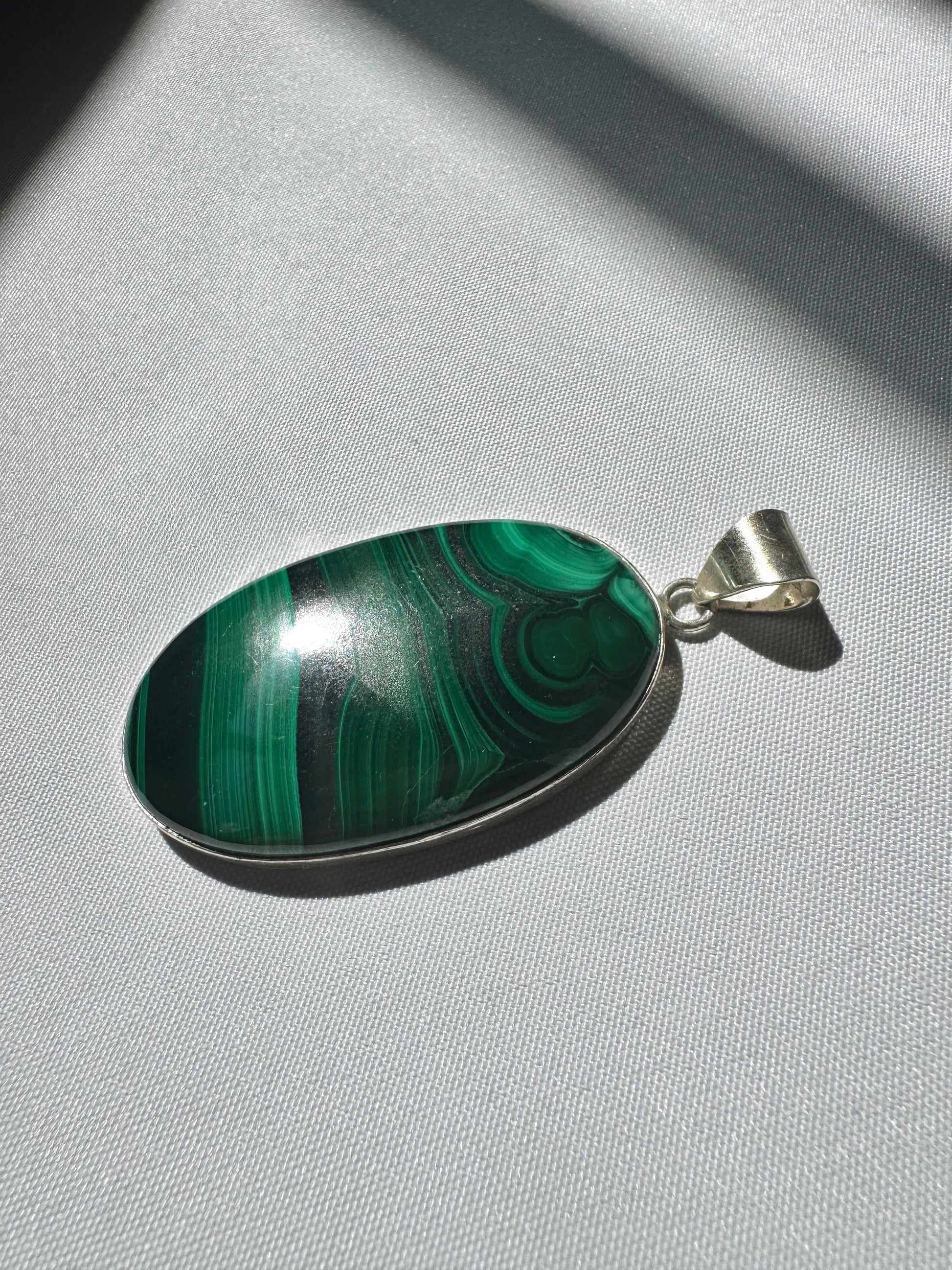 Malachite Pendant - Healing Crystal Jewellery NZ | polished green malachite stone with natural banding, set in a silver bezel.