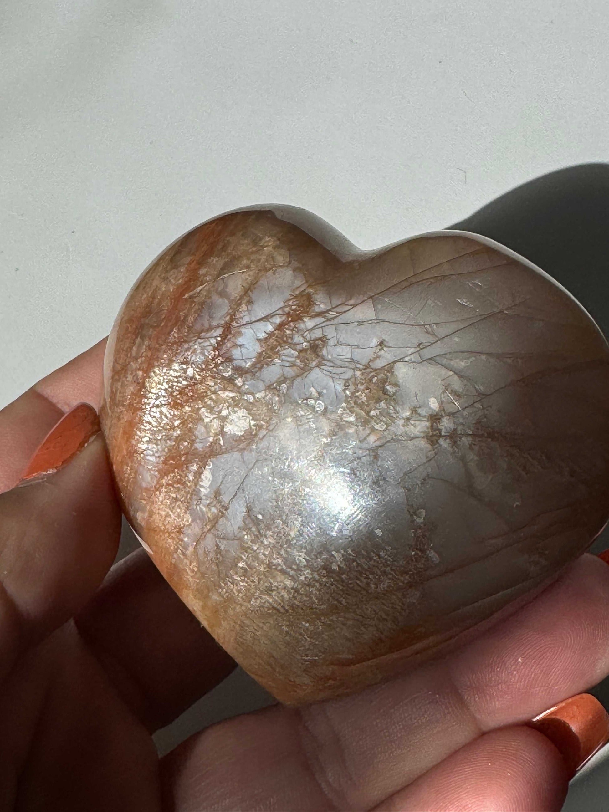 Handheld Peach Moonstone Heart #1 showing shimmering surface and natural inclusions, perfect for emotional healing and collectible crystal carvings | NZ Crystals