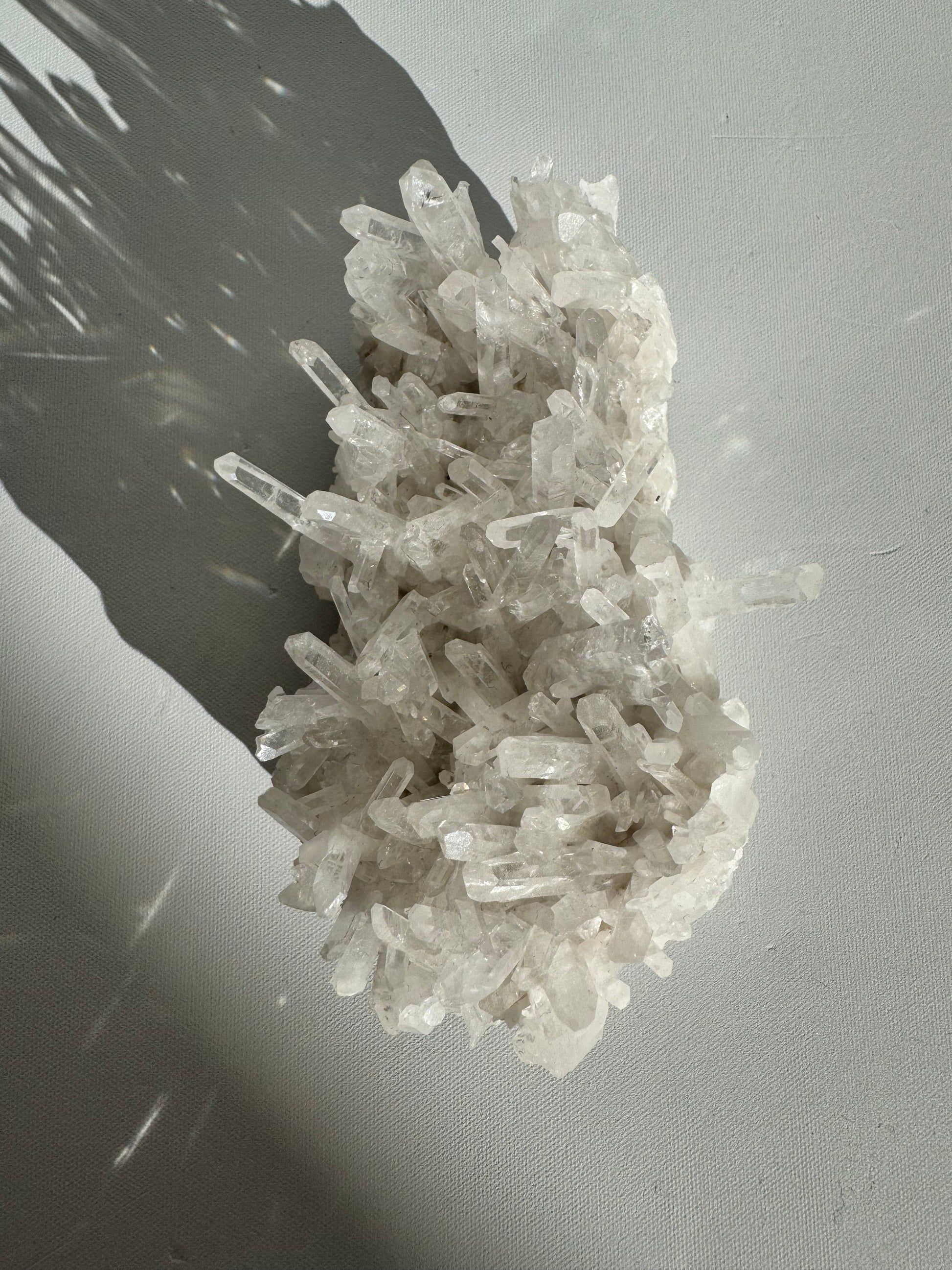 Needle Quartz Crystal Cluster featuring clear, elongated quartz points arranged densely on a white base, ideal for rock collectors and crystal enthusiasts.