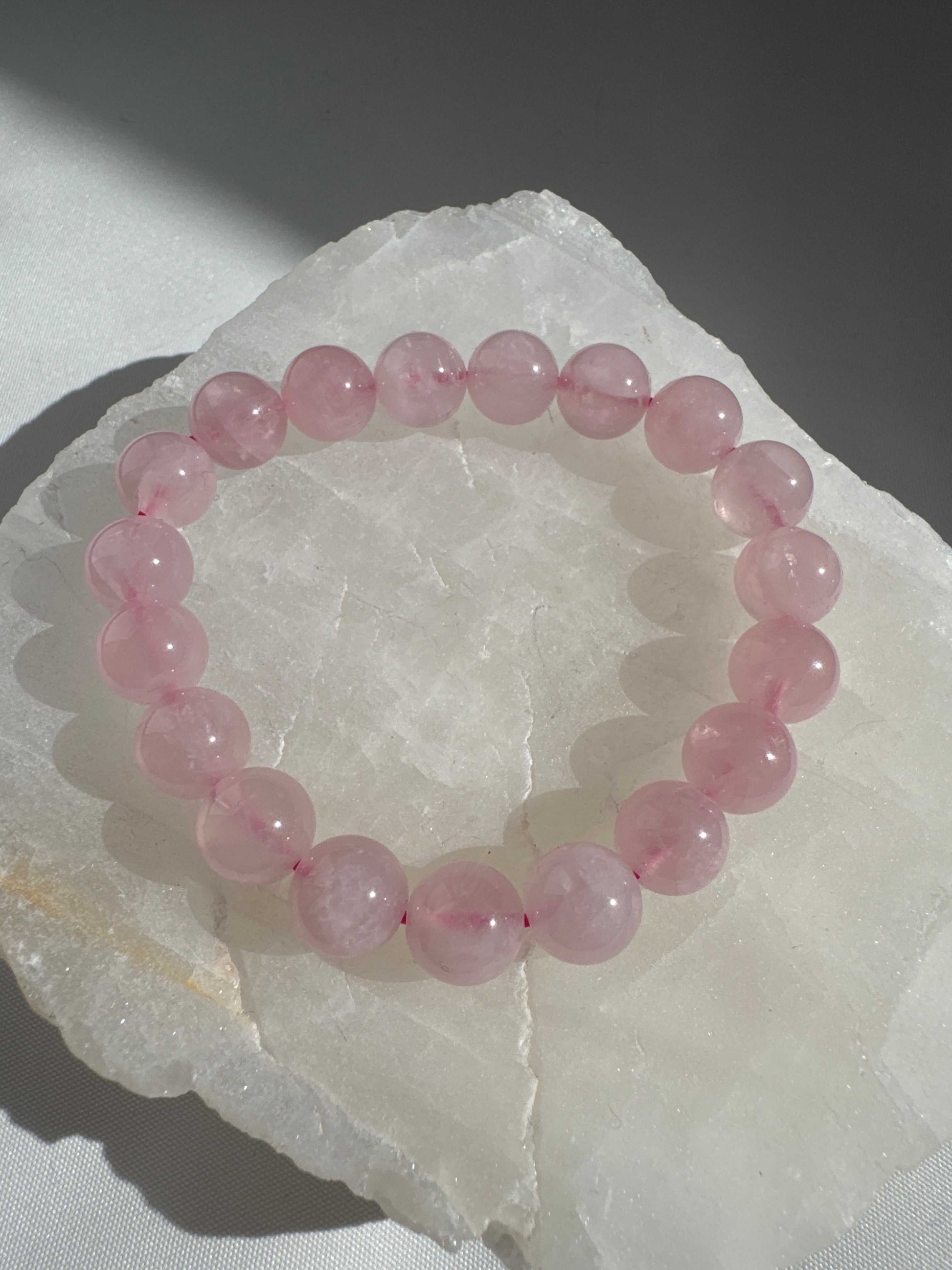 Single strand Rose Quartz Chakra Bracelet with glossy 10mm beads, ideal for heart chakra alignment and metaphysical harmony.