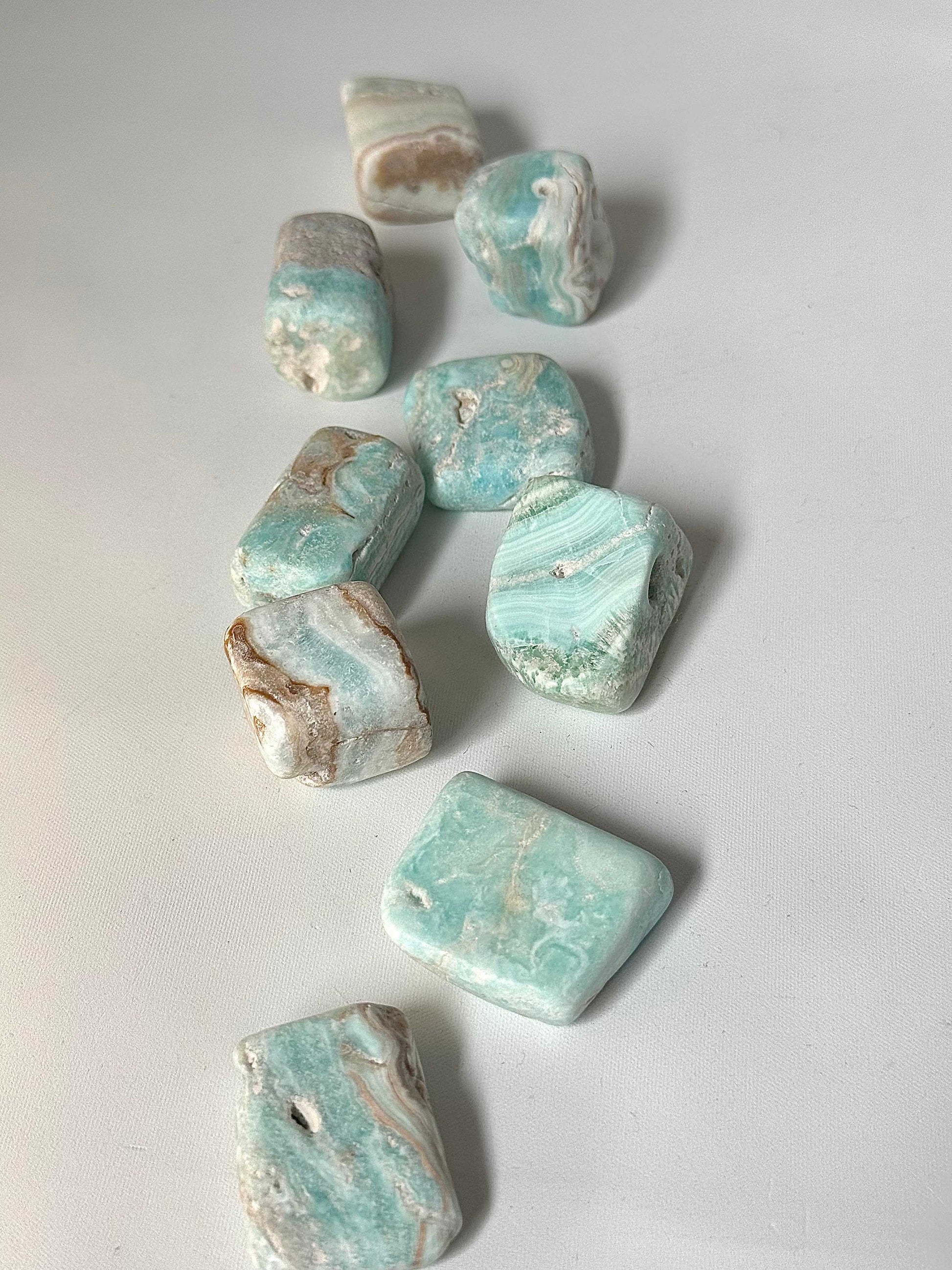 Assorted Blue Aragonite Tumble Stones in soft aqua tones, used for enhancing creativity and stress relief. Great addition to any crystal collection.