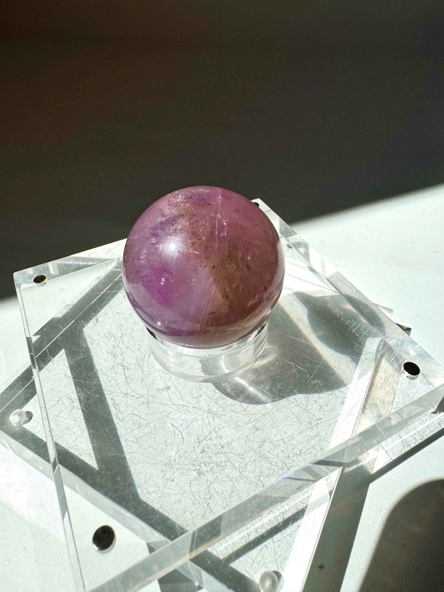 Ametrine Crystal Sphere #1 | Bespoke Crystals with vibrant amethyst and citrine tones, showcased on a transparent geometric base for collectors.