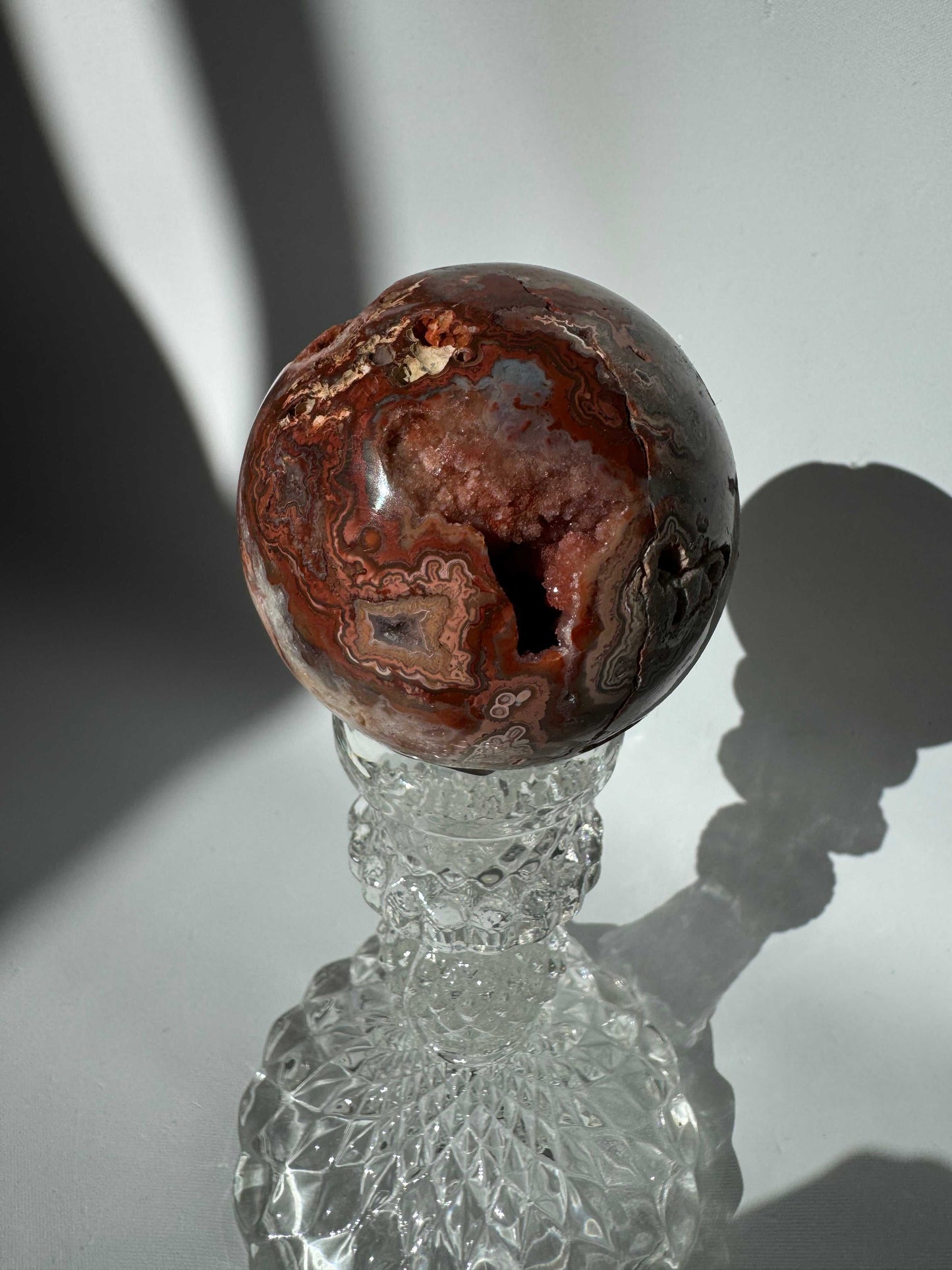 Polished Pink Crazy Lace Agate Sphere #3 showing intricate banding and a dark druzy | Bespoke Crystals
