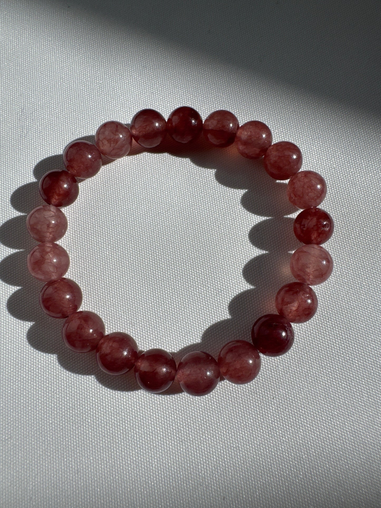 Bespoke Strawberry Quartz Crystal Bracelet featuring polished pink-red beads, perfect for compassionate energy and crystal healing accessories.