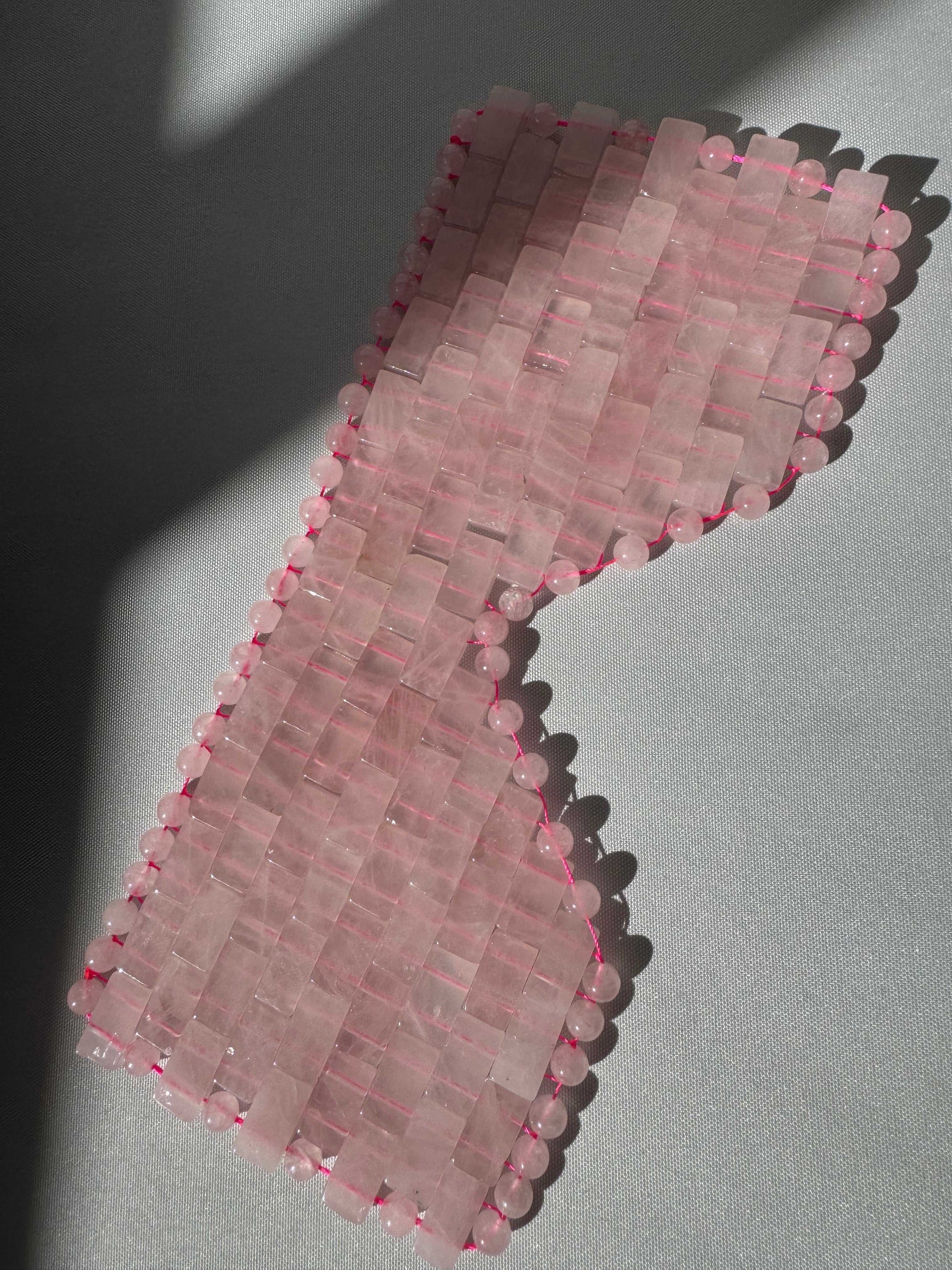 Close-up of Rose Quartz Crystal Eye Mask featuring interlinked rose quartz tiles. Promotes relaxation and skin rejuvenation.