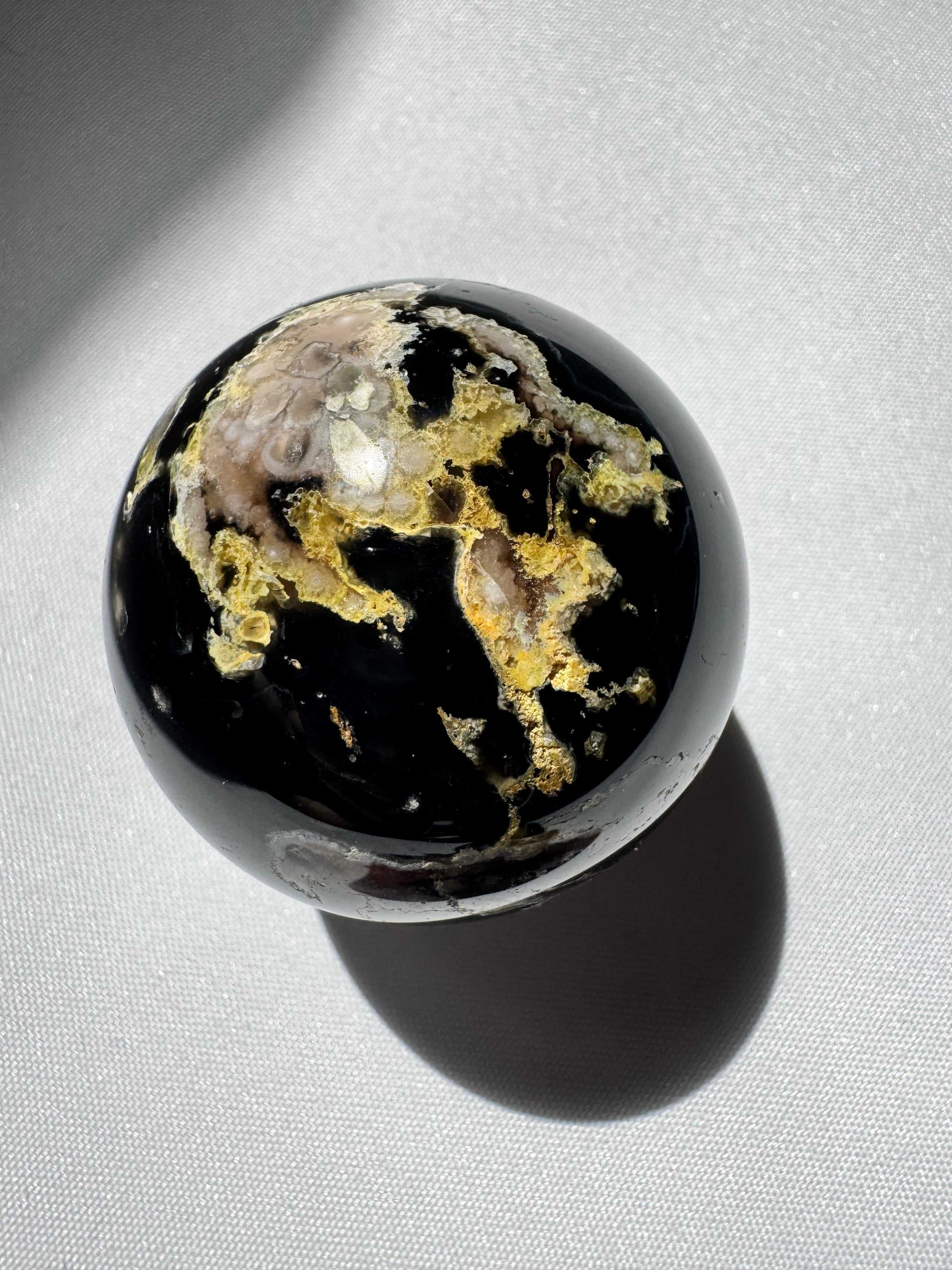 Unique Black Flower Agate Sphere showcasing vibrant yellow and beige inclusions, a collectible gemstone for grounding and peace | Online Crystal shops NZ