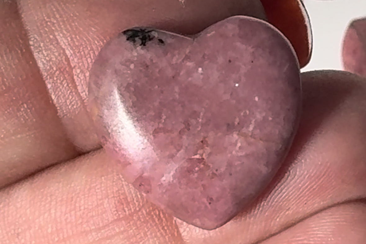 polished pink Rhodonite Crystal Mini Heart showcasing its smooth texture and natural patterns.
