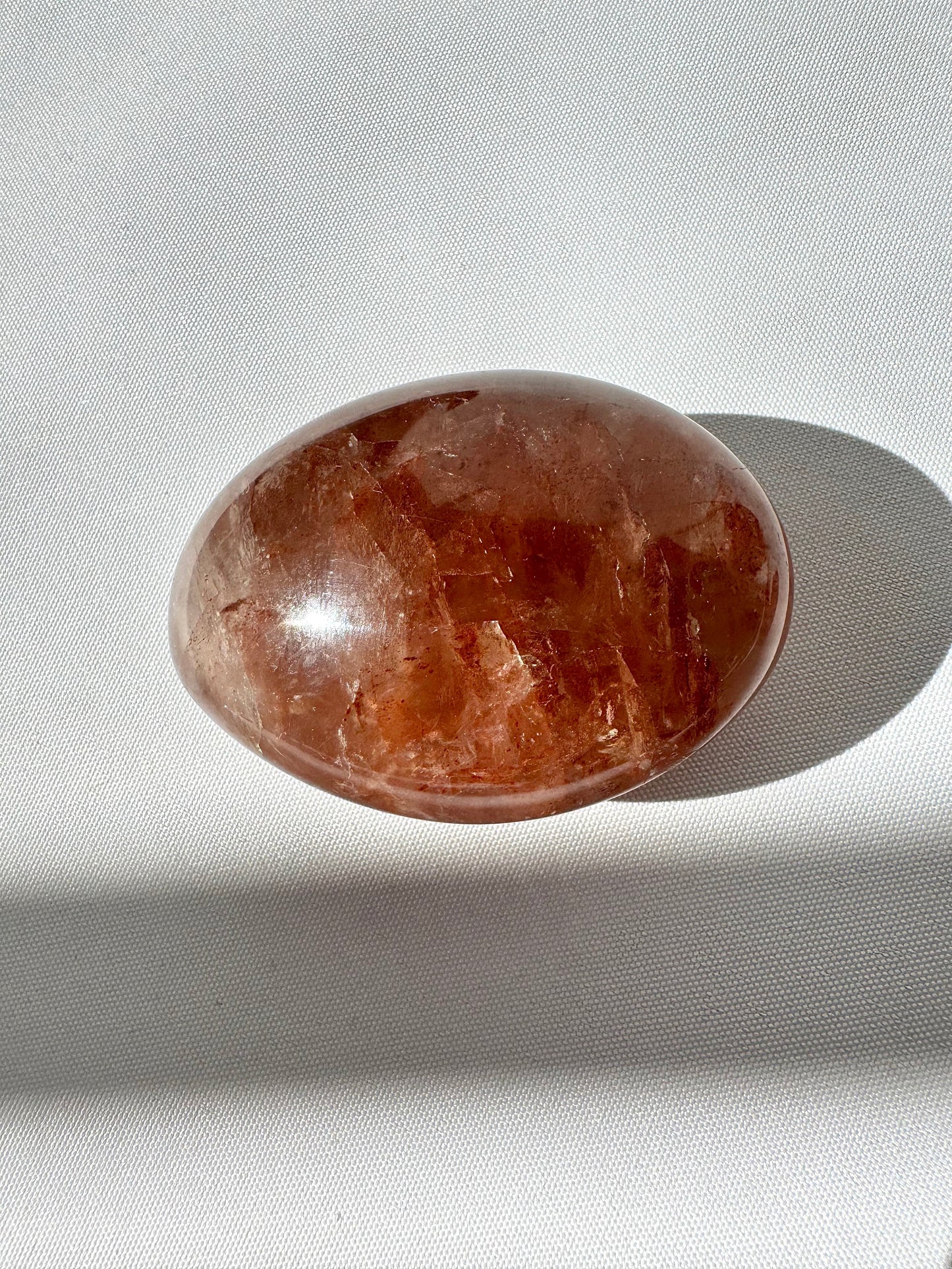 Single dark-toned Fire Quartz Palm Stone with rich red hematite inclusions, perfect for grounding and energy work in bespoke crystal collections.