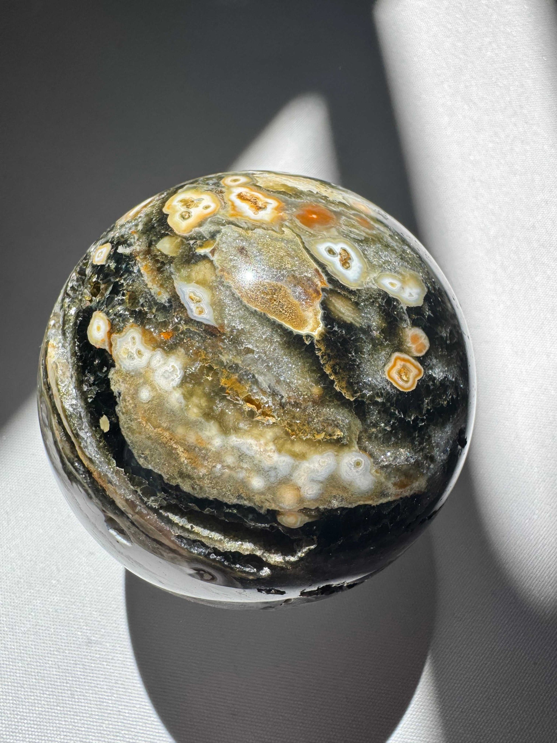 Orbicular Ocean Jasper Sphere #4 featuring vibrant orange, cream, and dark green orb formations with polished surface. A rare collectible from Madagascar | Healing Crystals NZ