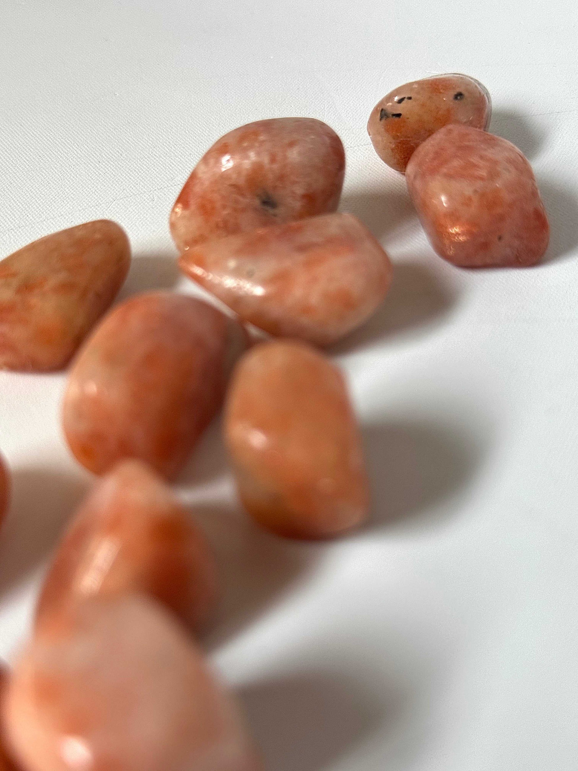 Sunstone Tumble Stone - Shop Online | Bespoke Crystals. Close-up of radiant sunstone tumbles showcasing natural inclusions and vibrant orange hues.