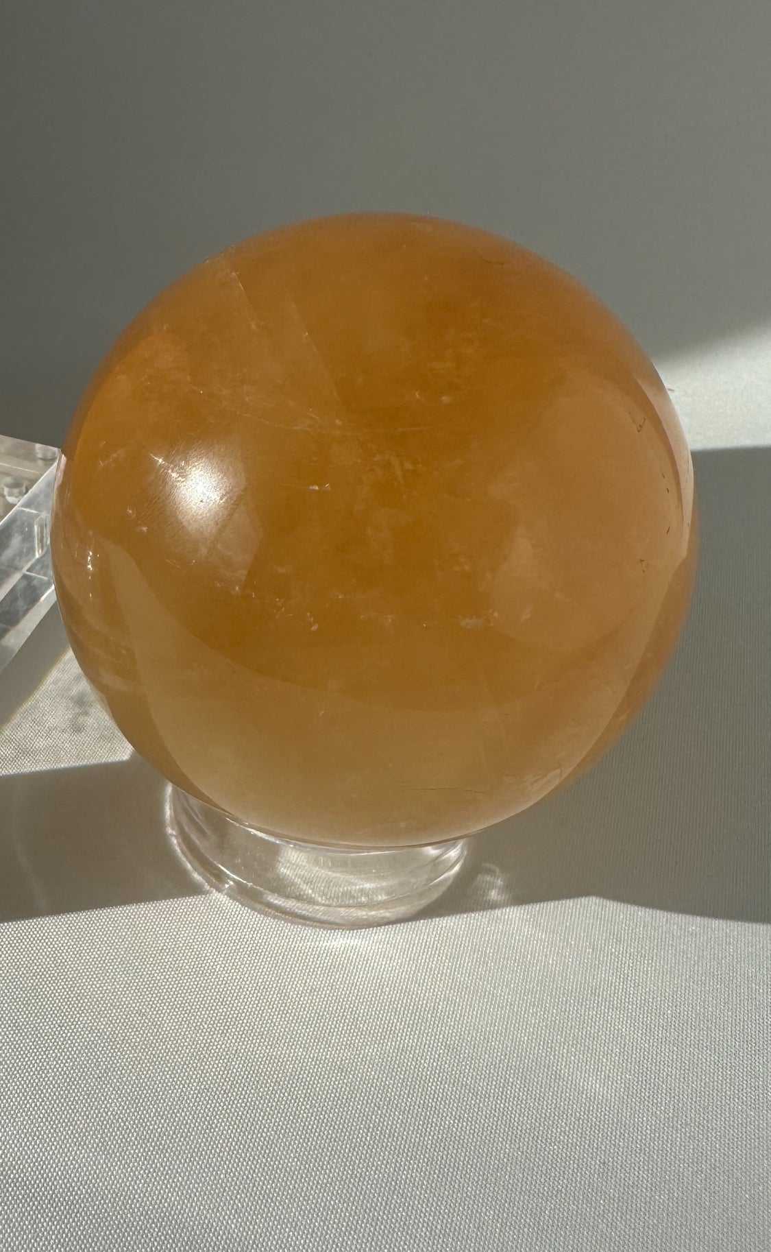 Polished Rainbow Honey Calcite Sphere with rich golden hues, ideal for healing energy and collectible crystal displays.