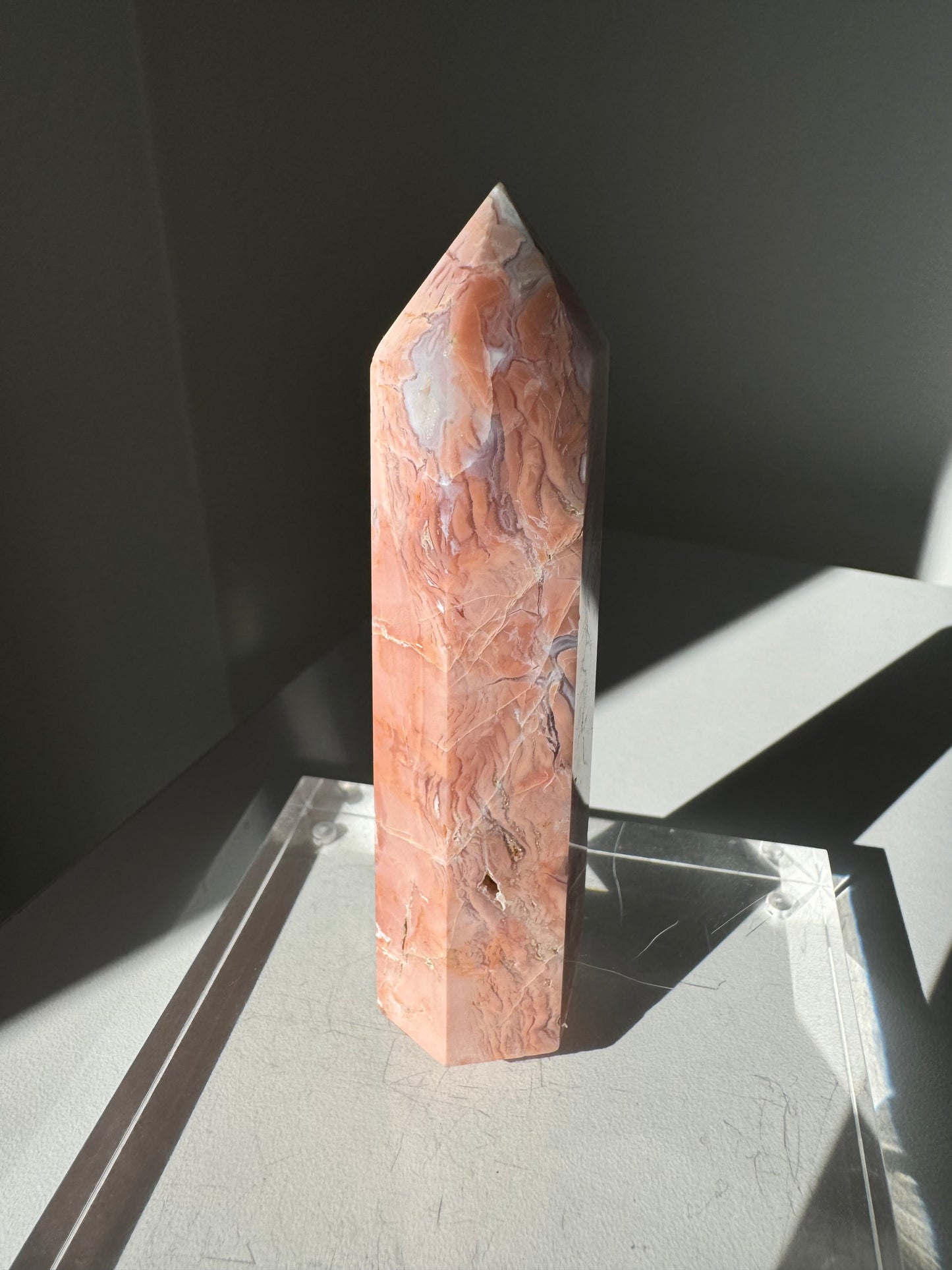 Cotton Candy Agate Crystal Point #1 with soft pink and peach brecciated jasper, polished and standing upright on a clear display base.