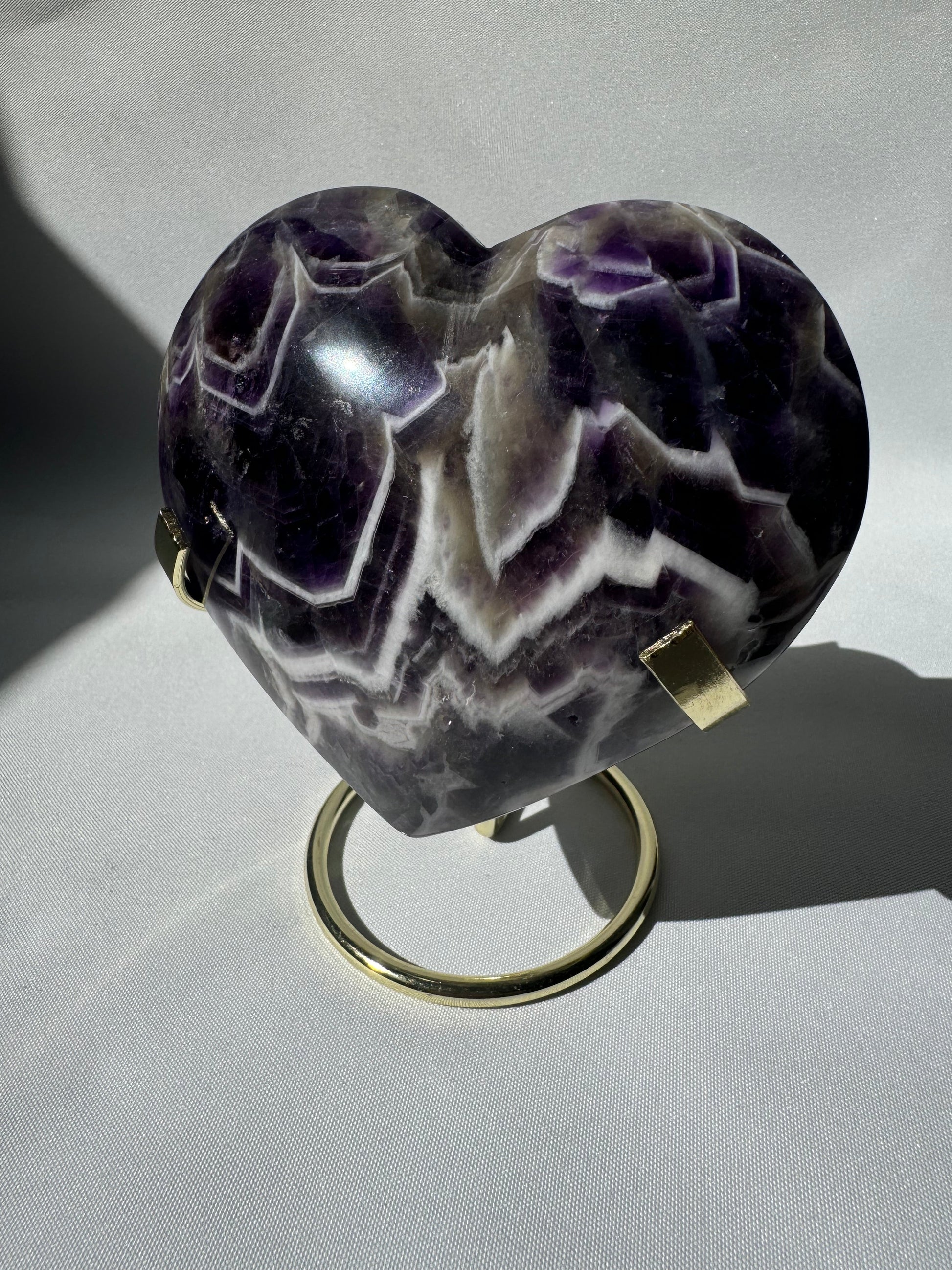 Large Chevron Amethyst Crystal Heart on gold stand with vivid purple and white banding, ideal for collectors and spiritual decor.