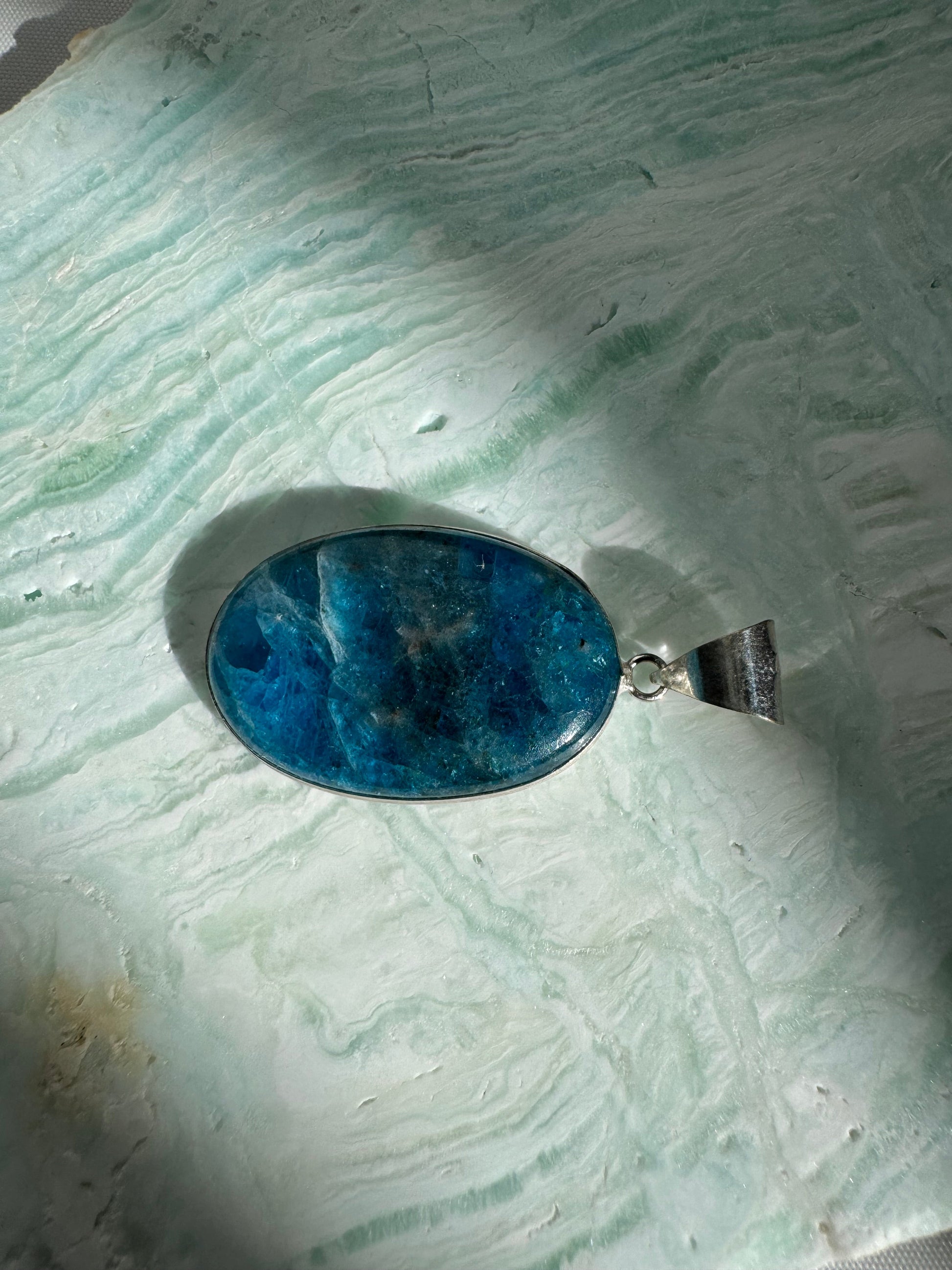 Close-up of Blue Apatite Crystal Sterling Silver Pendant showcasing vivid ocean-blue hues and polished 925 silver setting for elegant accessorizing.