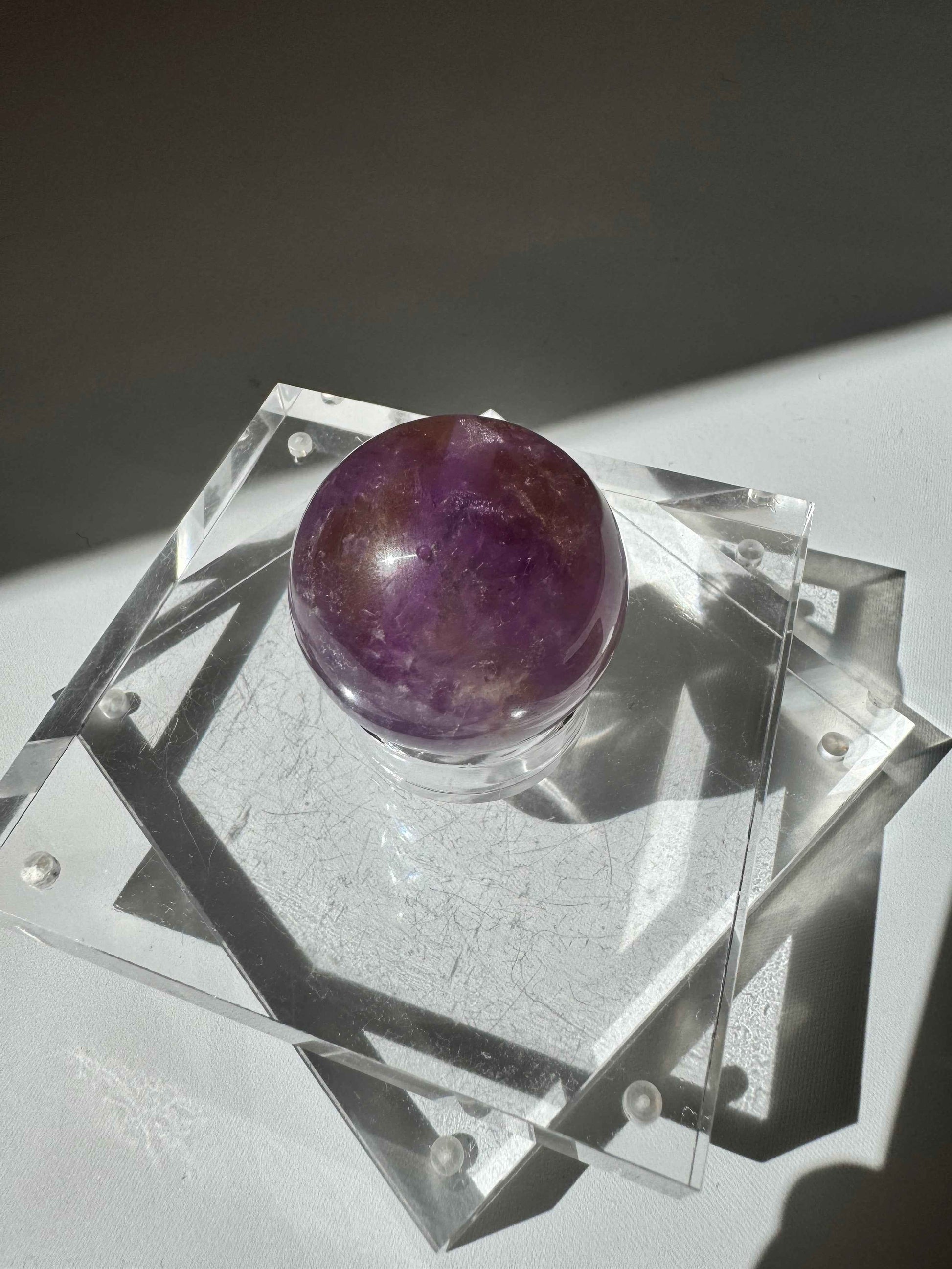 Polished Ametrine Crystal Sphere #2 with rich amethyst and citrine tones, placed on a geometric acrylic base for collectible display.
