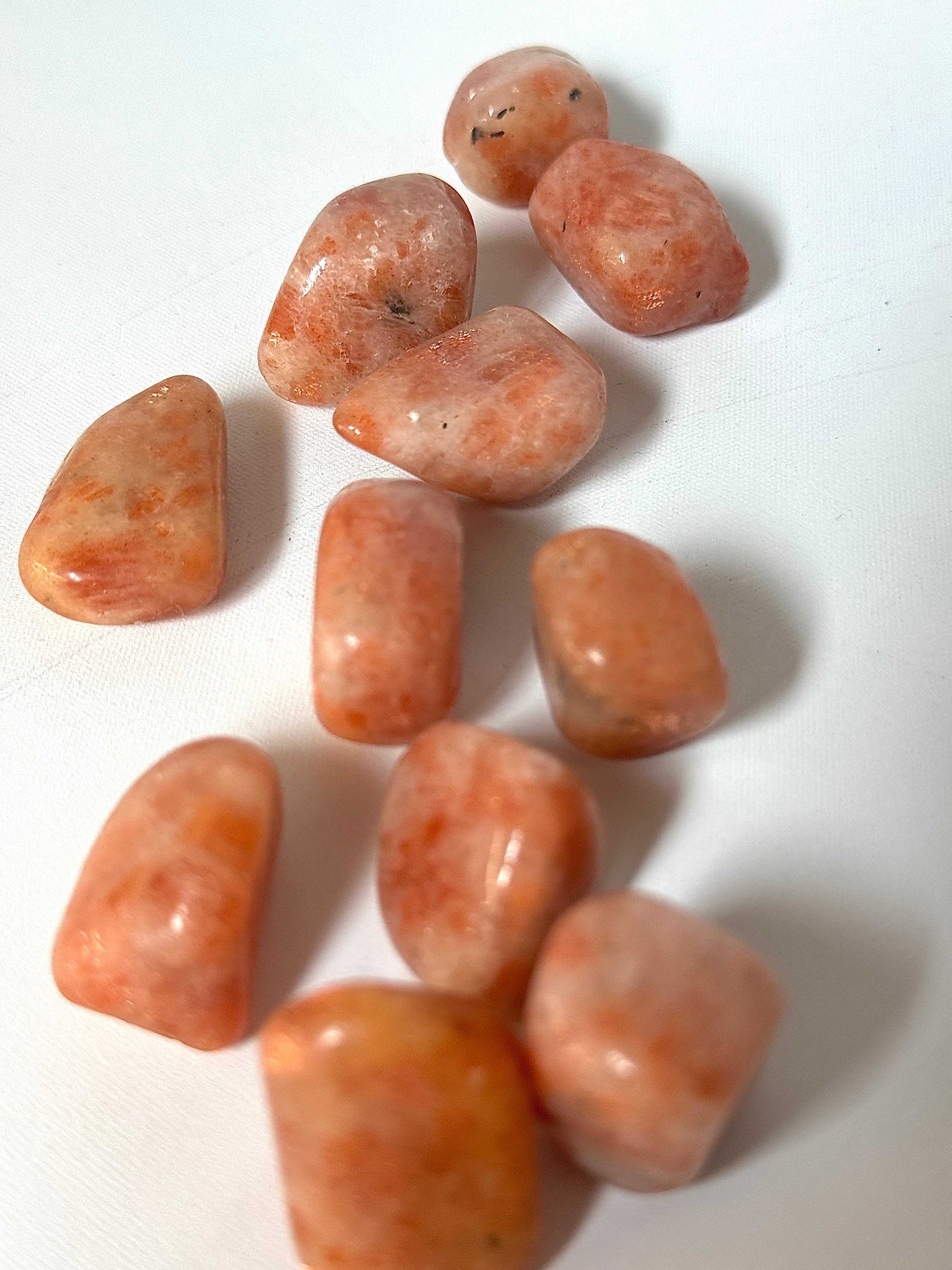 Sunstone Tumble Stone - Shop Online | Bespoke Crystals. Group of polished sunstone crystals with warm tones, ideal for enhancing creativity and positivity.