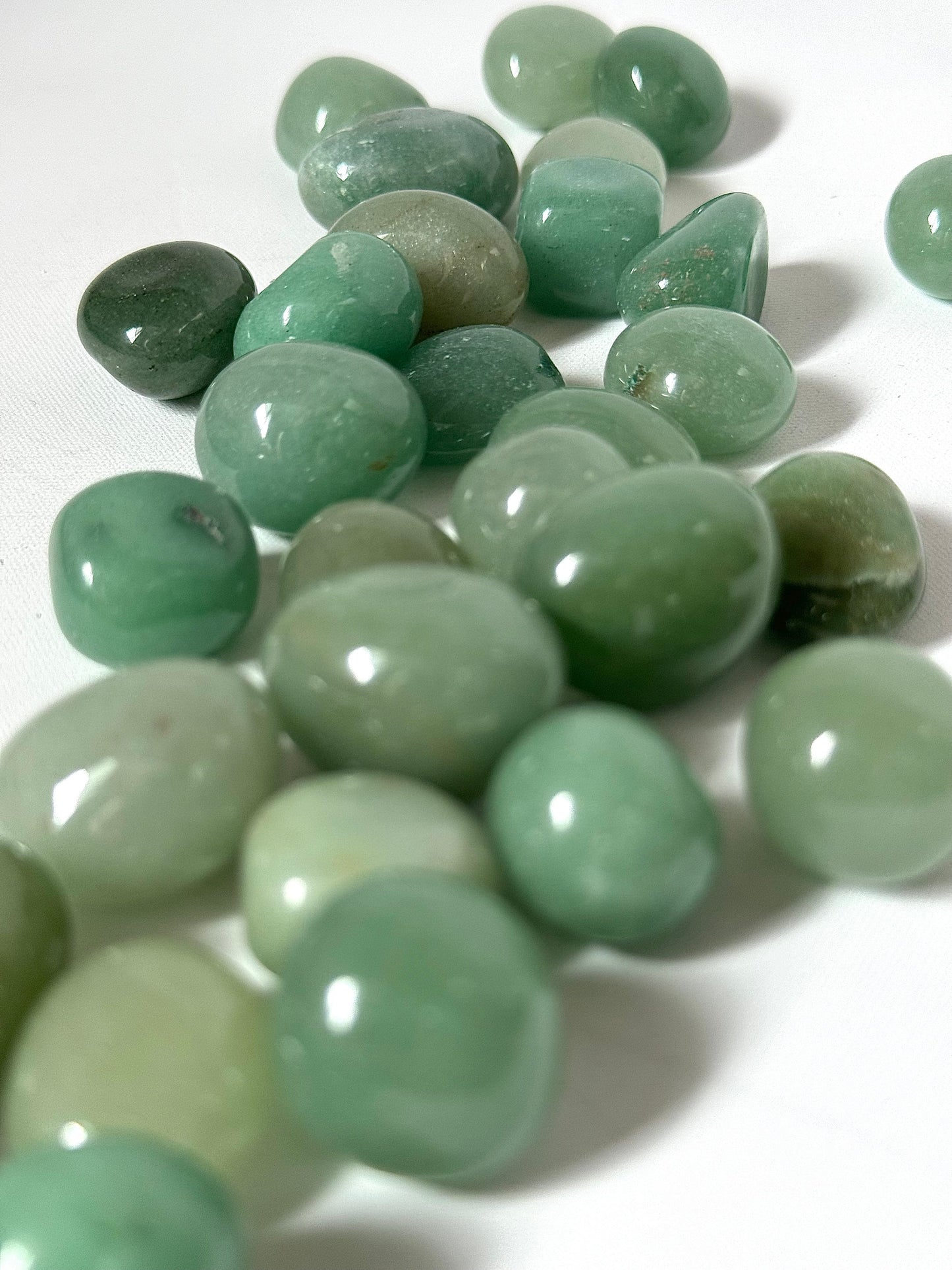 Close-up of Green Aventurine Tumble Stones | Bespoke Crystals showcasing polished texture and vibrant green hues for arts and crafts embellishments.