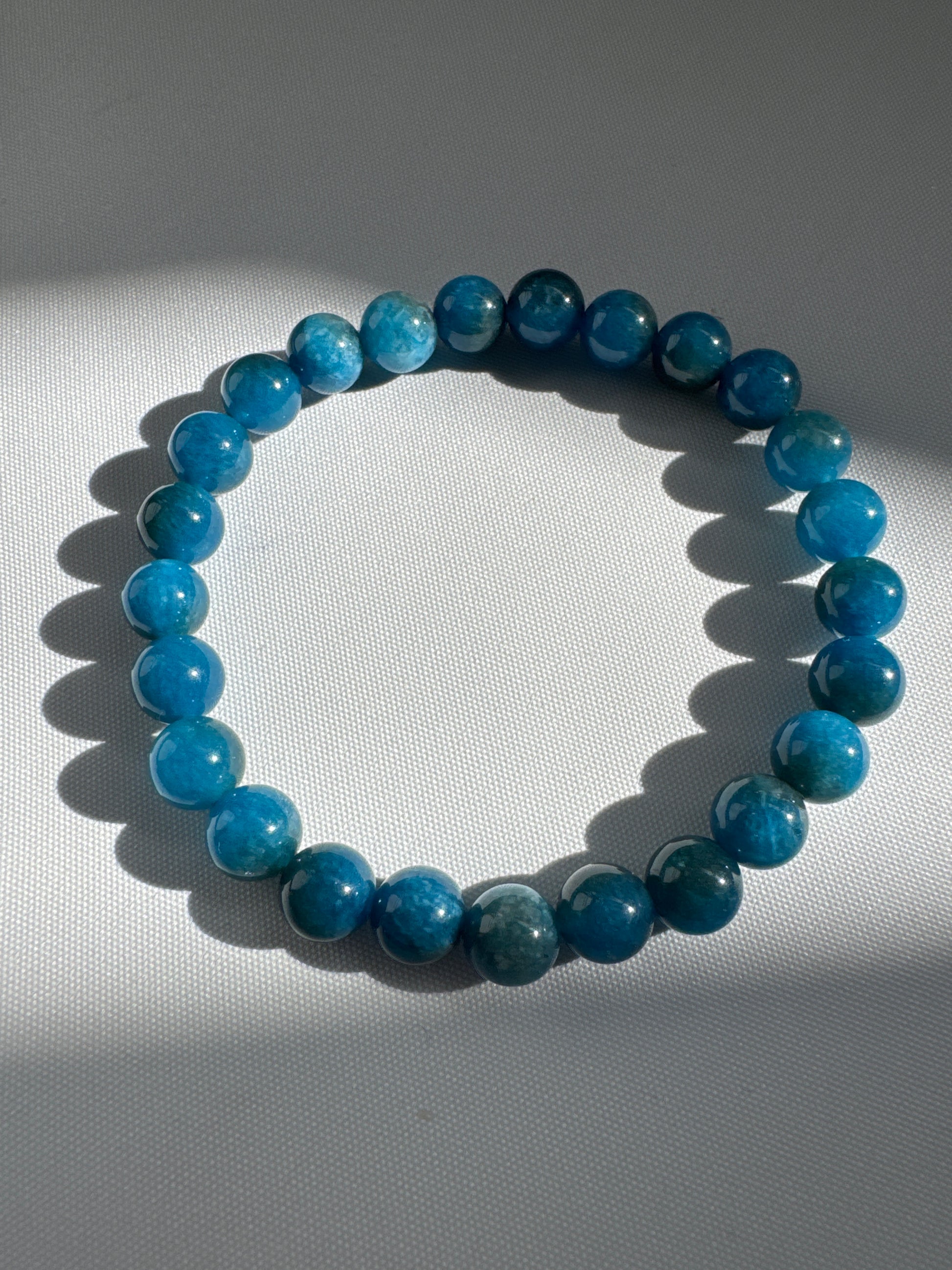 Blue Apatite Crystal Bracelet 8mm by Bespoke Crystals on a light background, highlighting polished blue gemstones ideal for spiritual jewellery