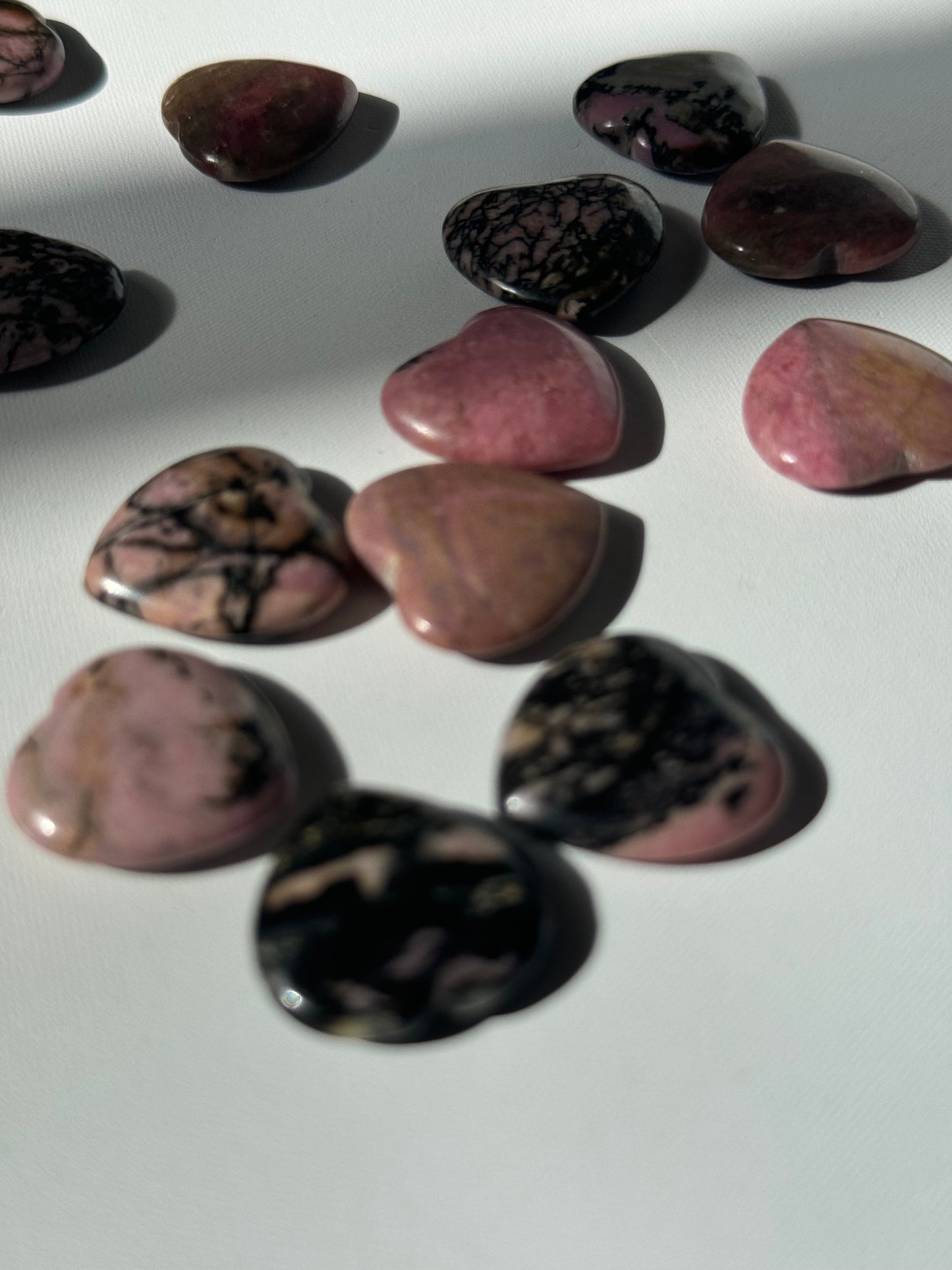 Assorted Rhodonite Crystal Mini Hearts in pink and black tones, ideal for crafts or spiritual decor from Bespoke Crystals collection.