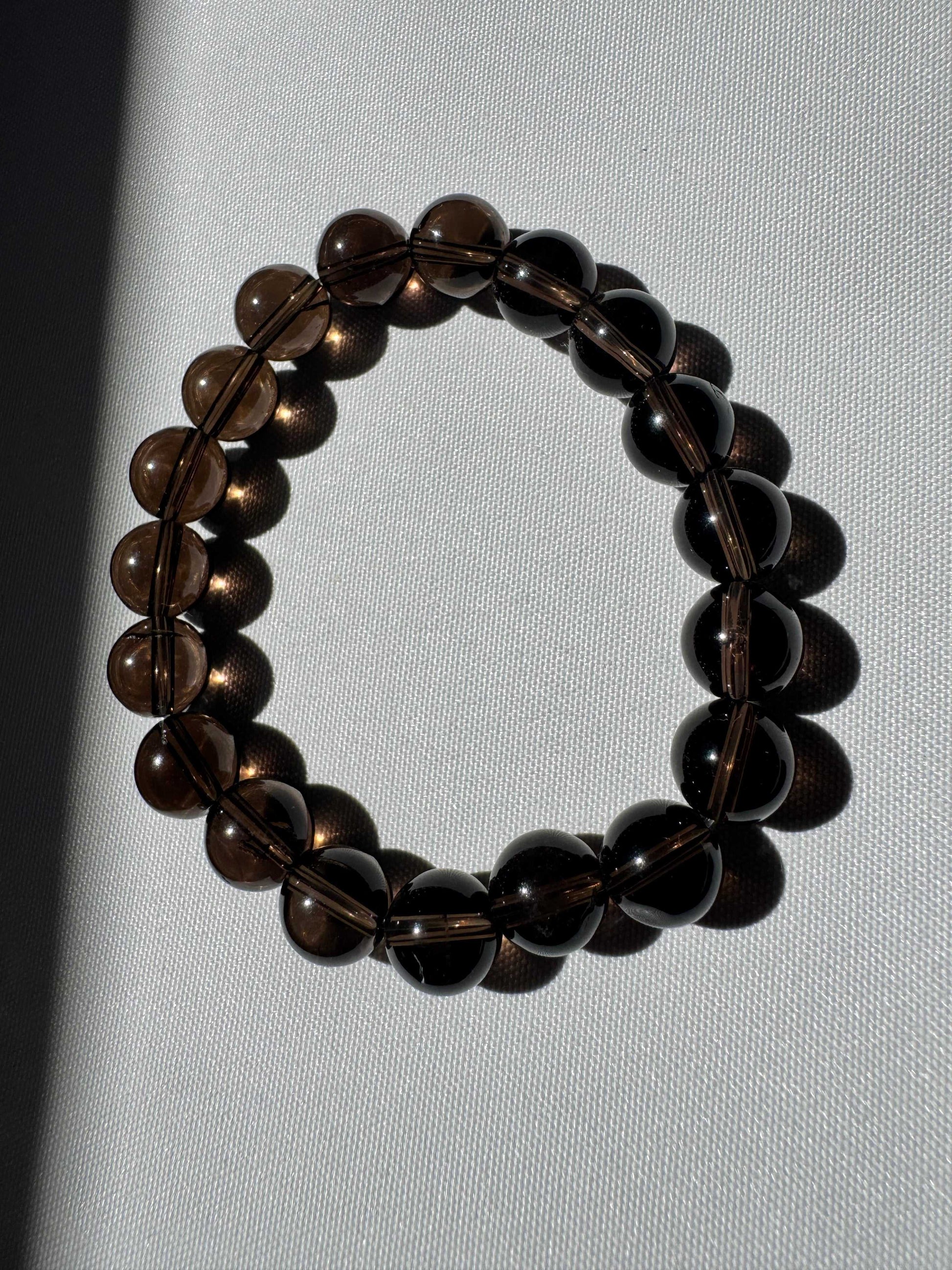 Smokey Quartz Bracelet - Grounding Protection 10mm shown in natural light, highlighting its translucent brown crystal beads.