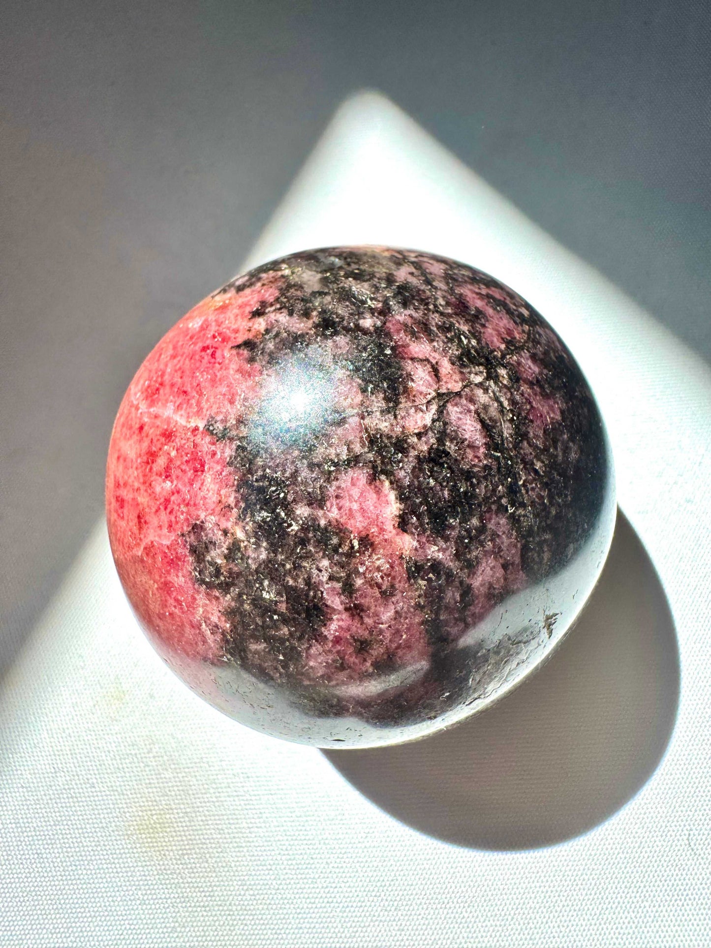 Rhodonite Sphere - Buy Healing Crystals NZ | Polished pink and black Rhodonite crystal sphere for emotional healing and chakra alignment.