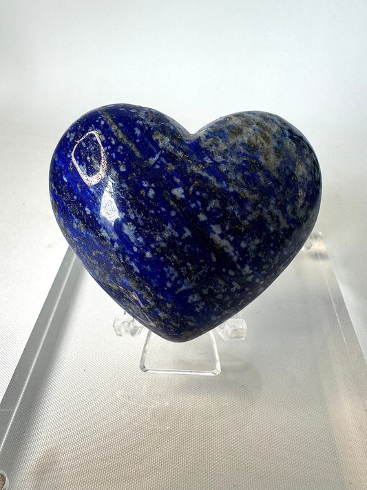 Lapis Lazuli Heart | Bespoke Crystals collectible featuring deep blue hues with golden pyrite flecks, displayed upright on a clear acrylic stand.