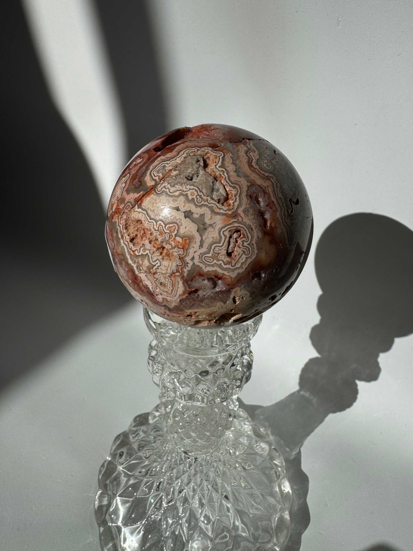 Detailed view of Pink Crazy Lace Agate Crystal Druze Sphere #3 featuring swirling pink, grey, and red patterns, a standout collectible crystal piece | Bespoke Crystals