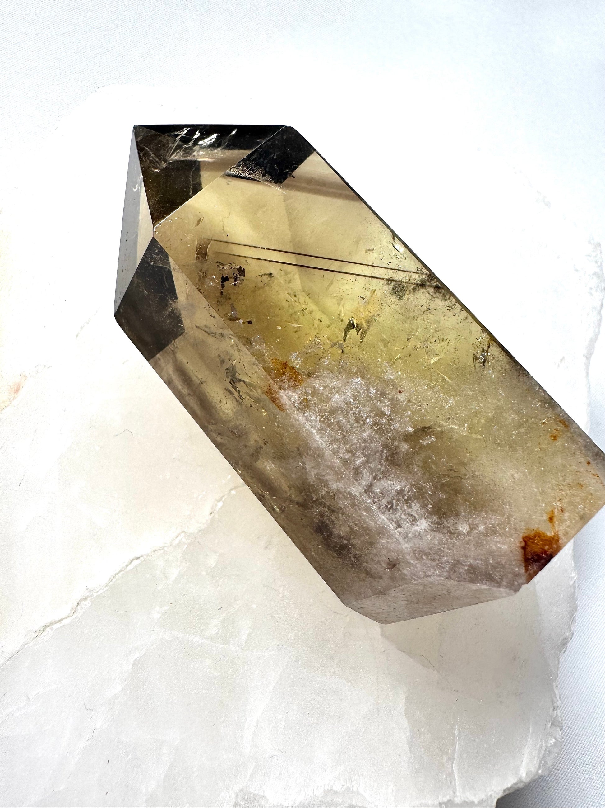 Citrine Crystal Point | Bespoke Crystals featuring a phantom inclusion, displayed on a white stone slab. Ideal for collectors and energy work.
