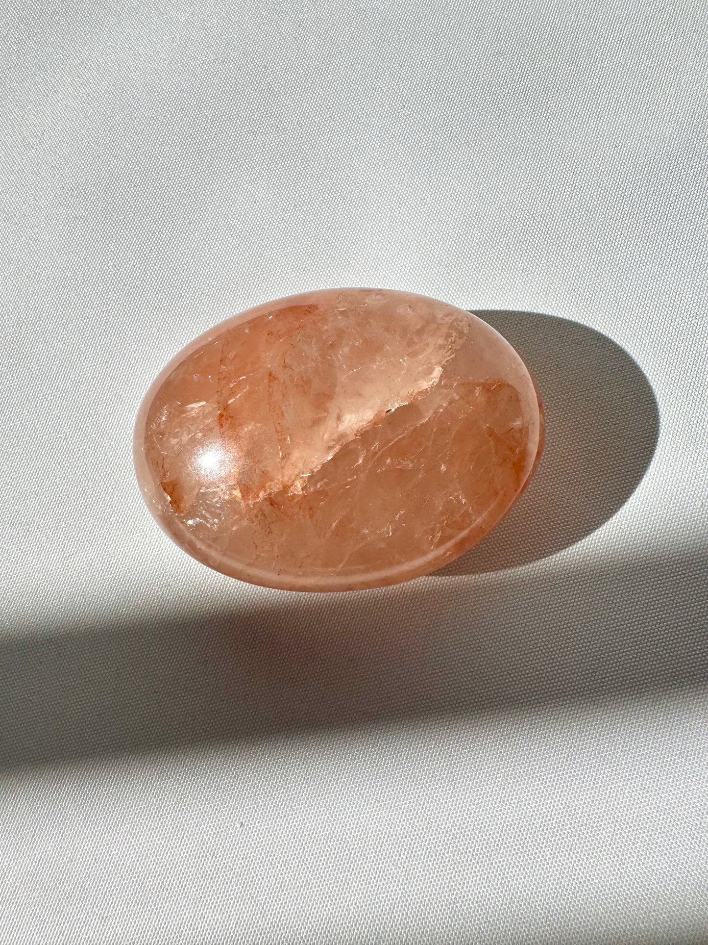 Mid-tone Fire Quartz Crystal Palm Stone with visible iron oxide streaks, ideal for enhancing vitality and emotional balance in crystal therapy.