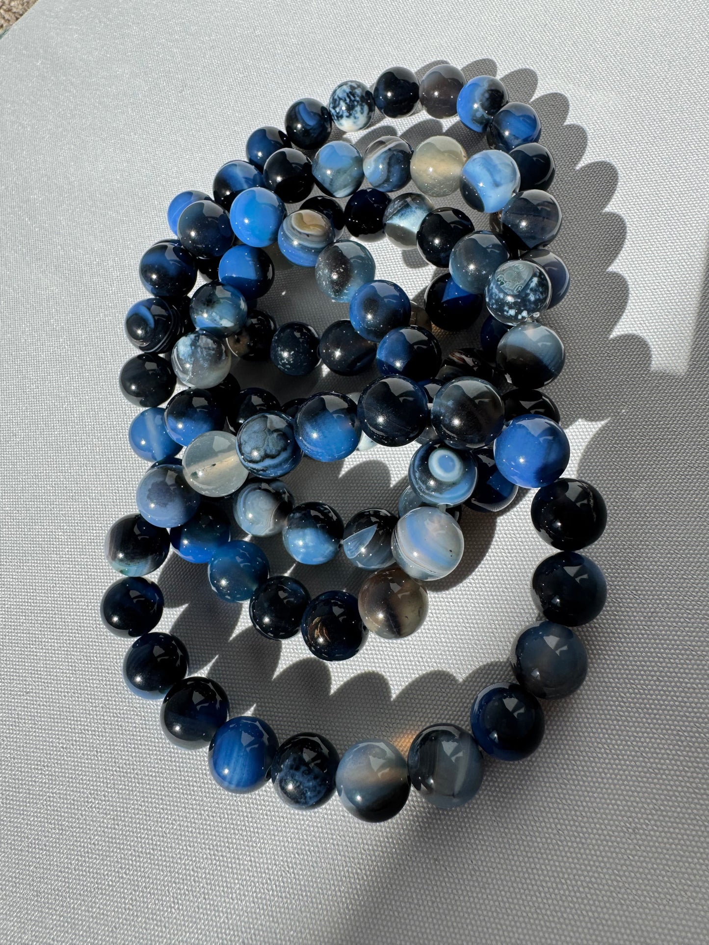 Blue Agate Crystal Bracelet 10mm from Bespoke Crystals featuring polished round beads in deep and light blue tones, ideal for emotional clarity.