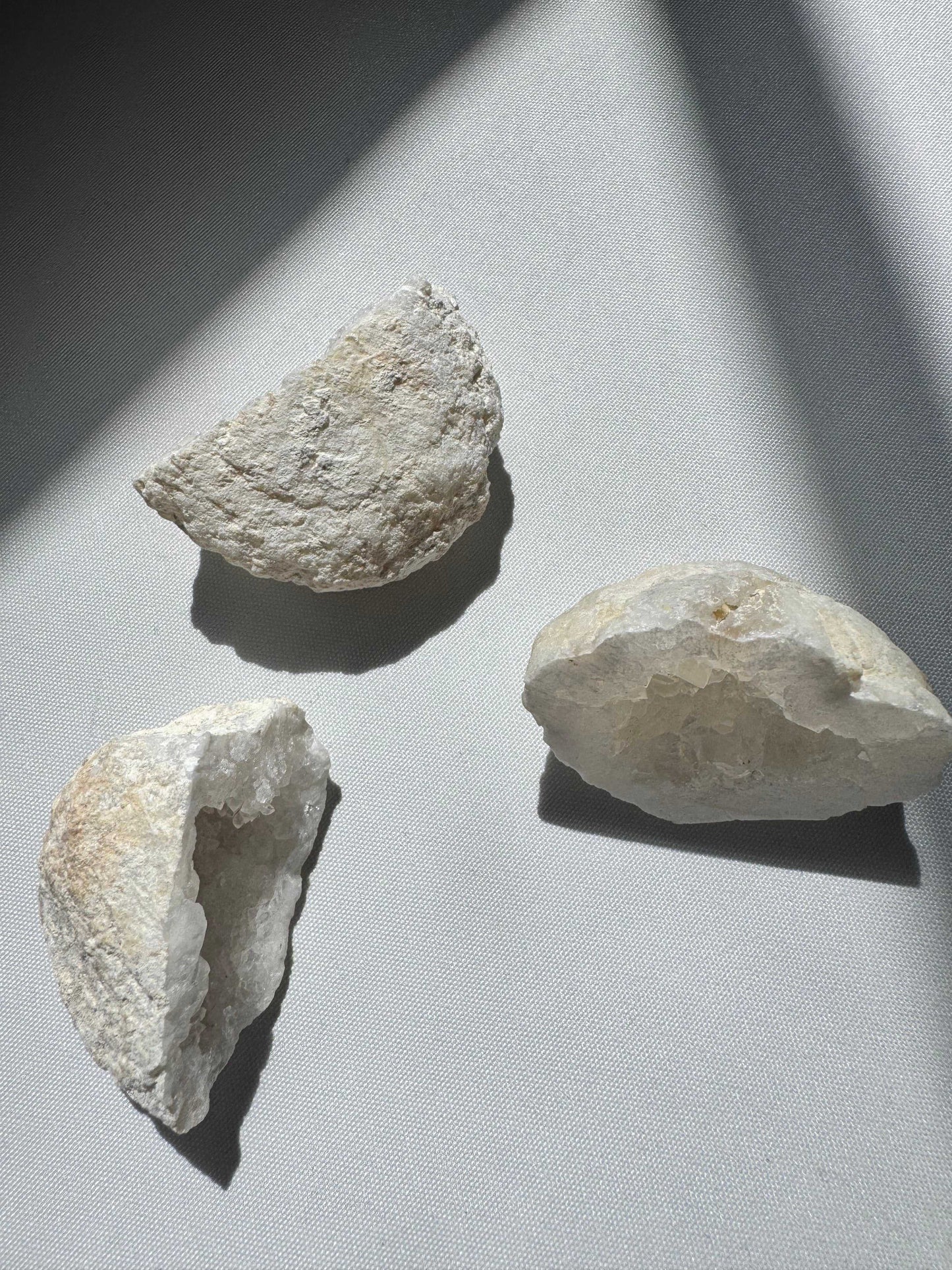 Three Small Quartz Crystal Geode Halves showcasing rough exteriors and glittering interiors, perfect for spiritual balance and collectible displays | Bespoke Crystals Auckland NZ