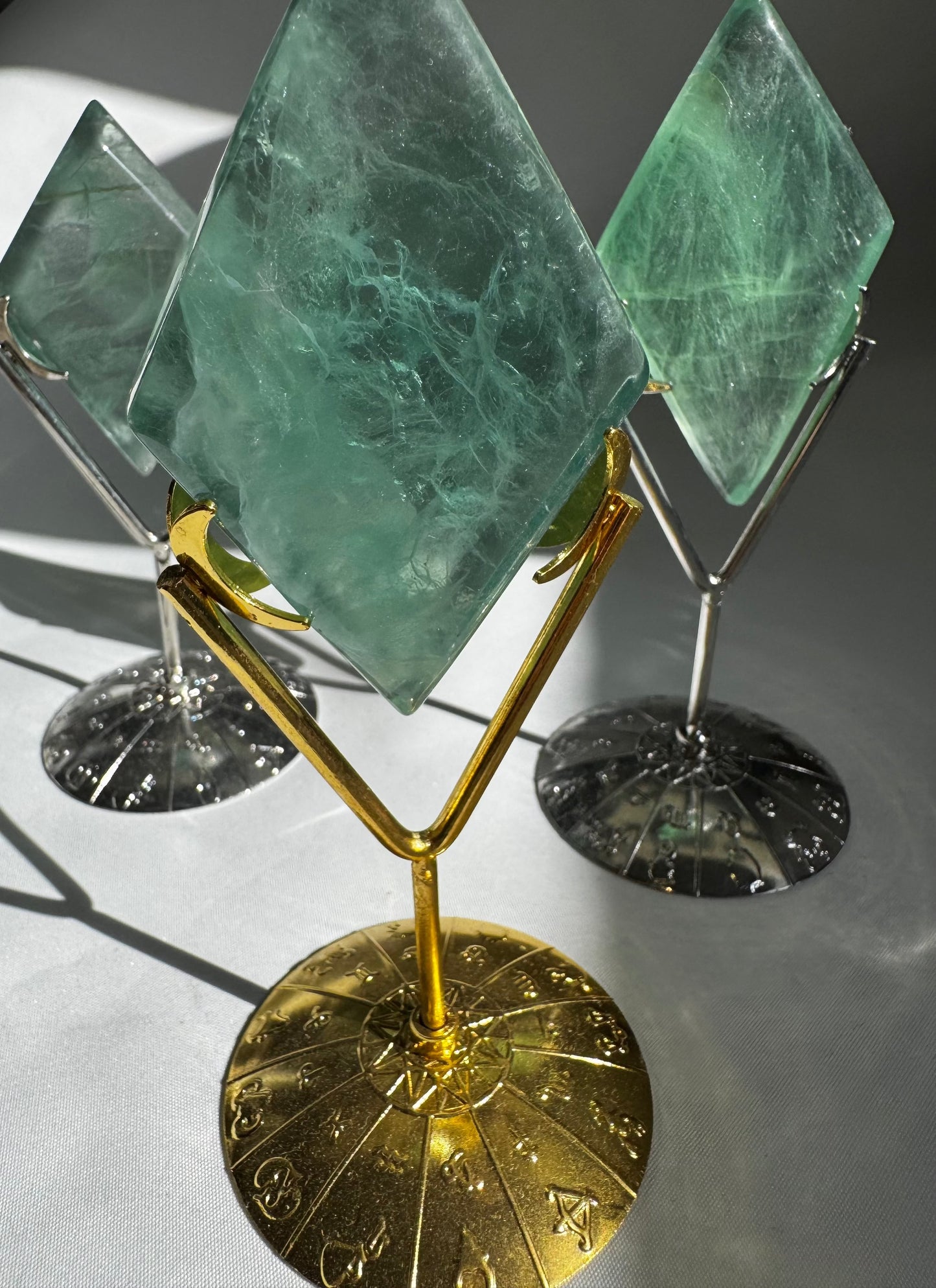 Set of Green Fluorite Crystal Diamonds on gold and silver zodiac stands by Bespoke Crystals, perfect for crystal collectors and home décor.