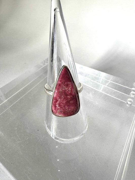 Thulite Crystal Ring | Bespoke Crystals featuring a polished pink Thulite stone set in sterling silver, displayed on a clear ring stand.