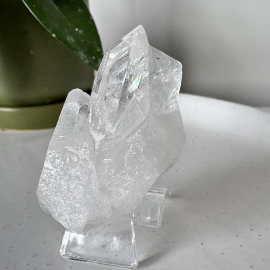 Quartz Cluster (Brazil) #3 from Bespoke Crystals Auckland displayed on a clear stand, showcasing natural clarity and raw crystal formations.