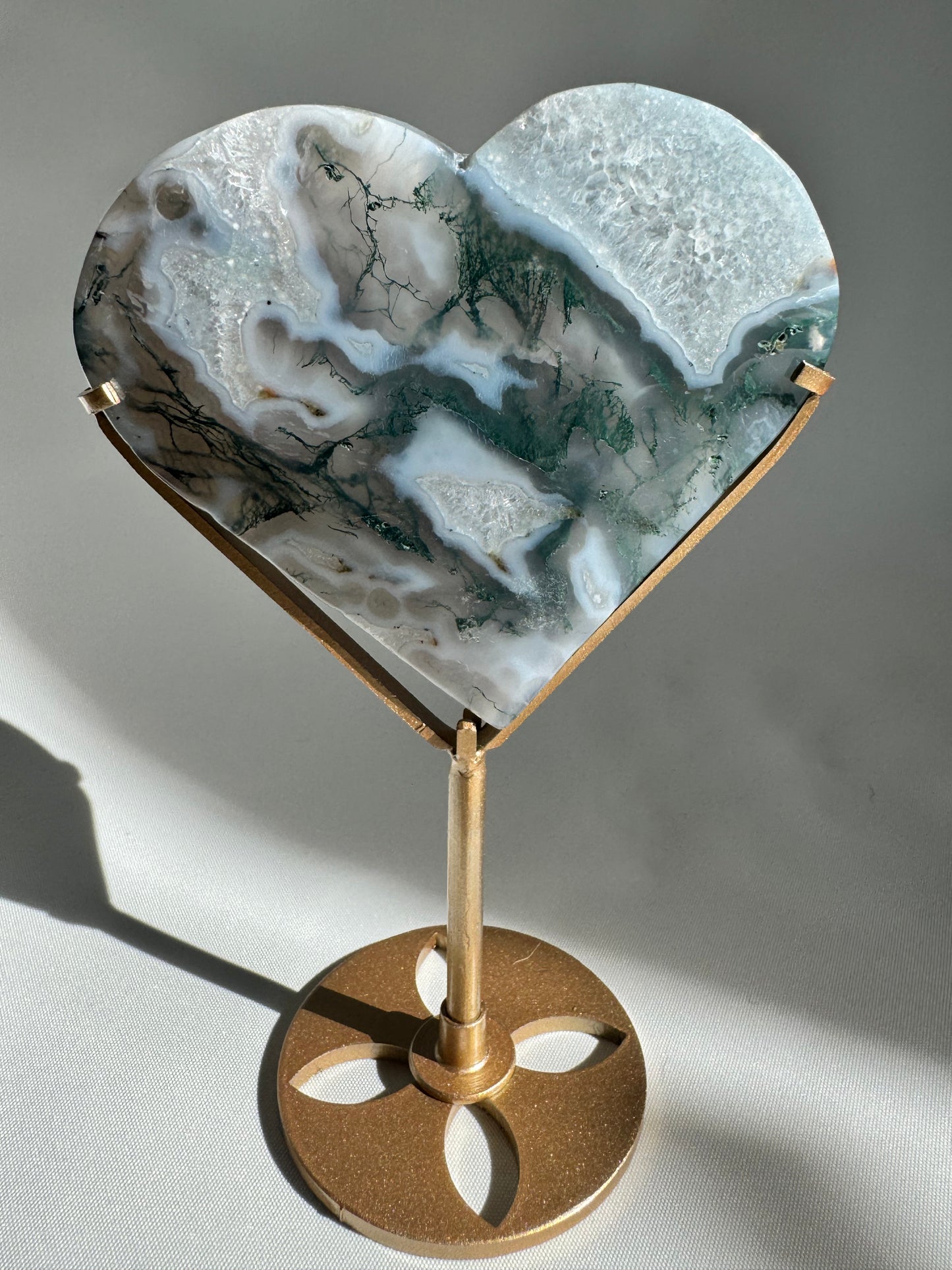 Moss Agate Heart stone with intricate green and white inclusions, on display stand