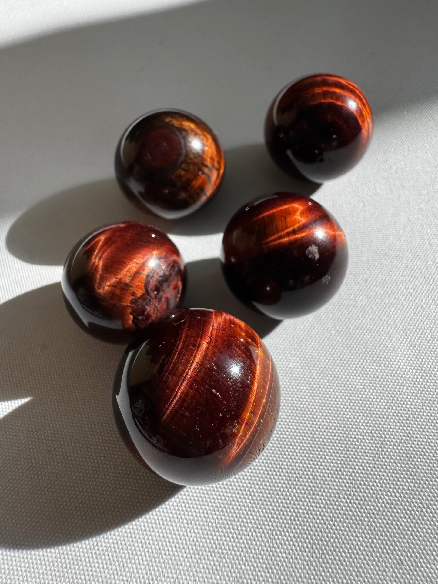 Red Tigers Eye Crystal Mini Sphere with fiery red and brown bands, ideal for collectors of rocks and fossils in the metaphysical crystal category.