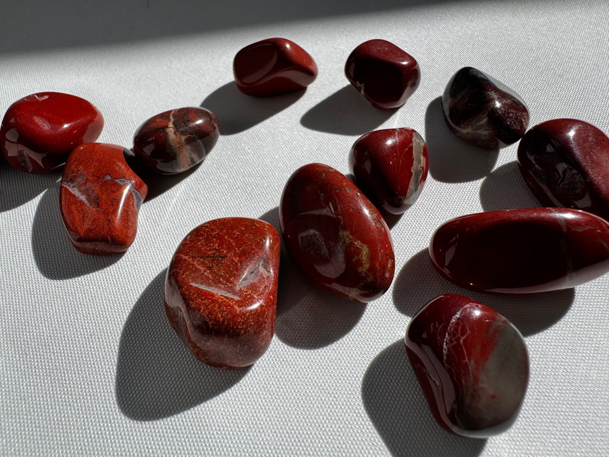 Polished Red Jasper Crystal Tumble Stones with deep red and earthy tones, ideal for grounding and energy work in crystal healing collections.