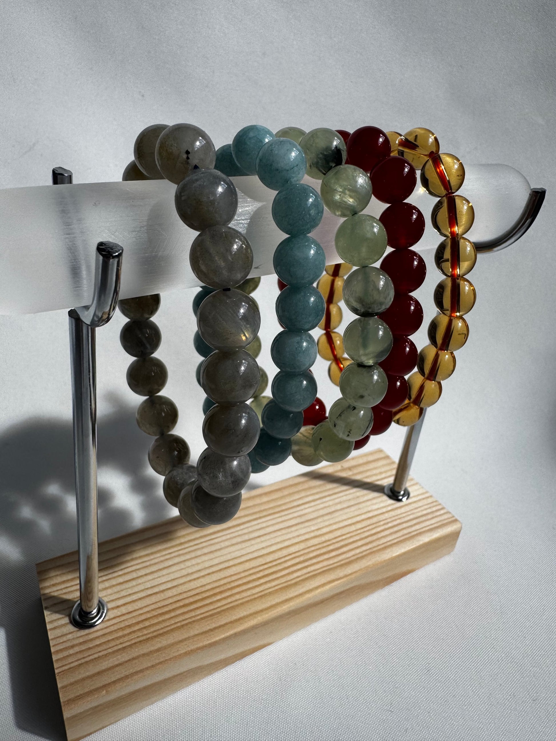 Selenite Bracelet Holder - Display Stand holding colourful stone bracelets. Elegant jewellery display with selenite rod and wooden base for hom