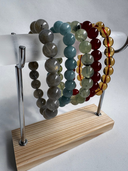 Selenite Bracelet Holder - Display Stand with crystal bead bracelets on a wooden base and chrome supports. Ideal for organizing jewellery collections.