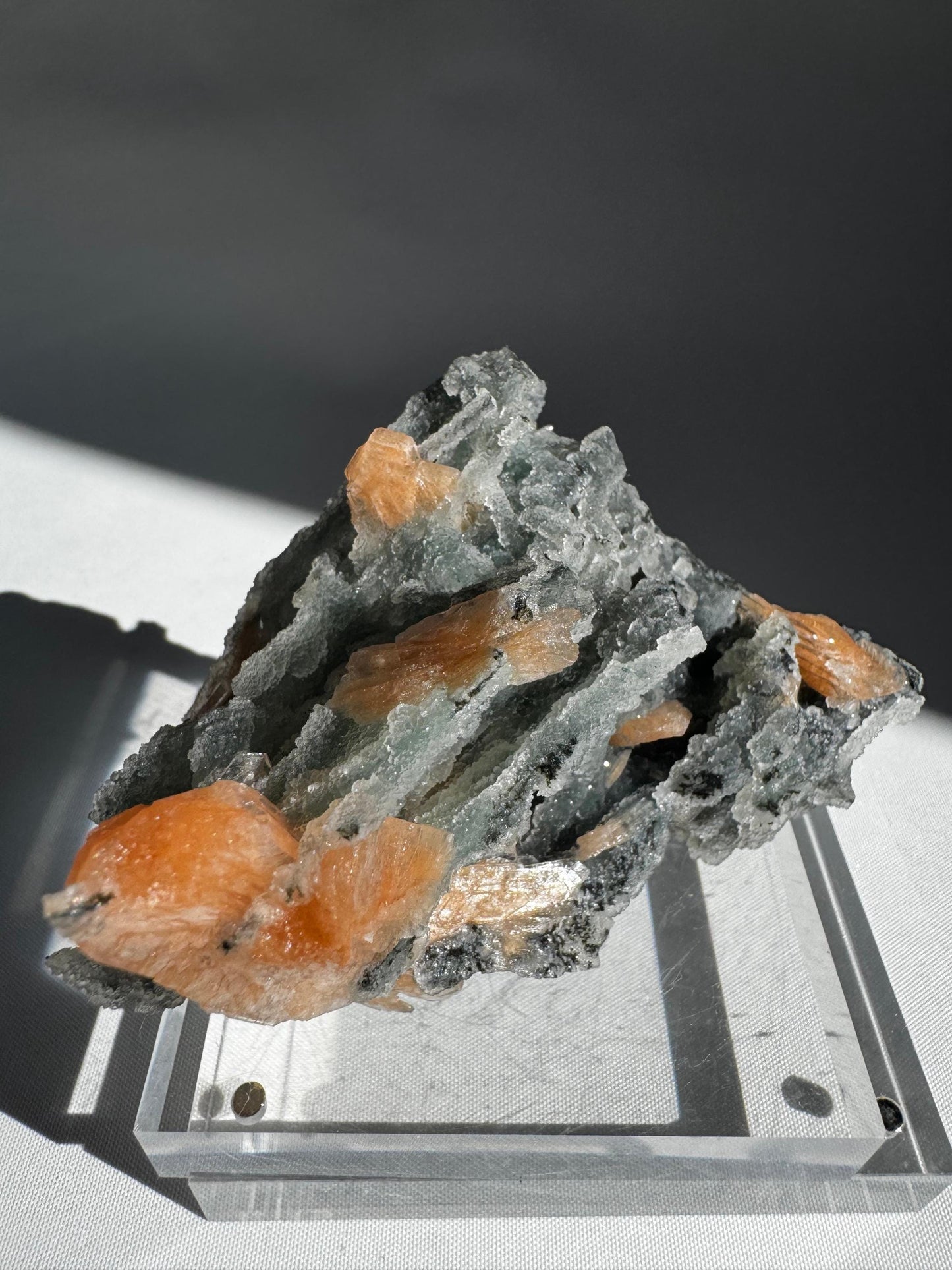Angled close-up of Chalcedony with Orange Stilbite Crystal #8 highlighting the contrast between soft white Chalcedony and vivid orange Stilbite crystals.