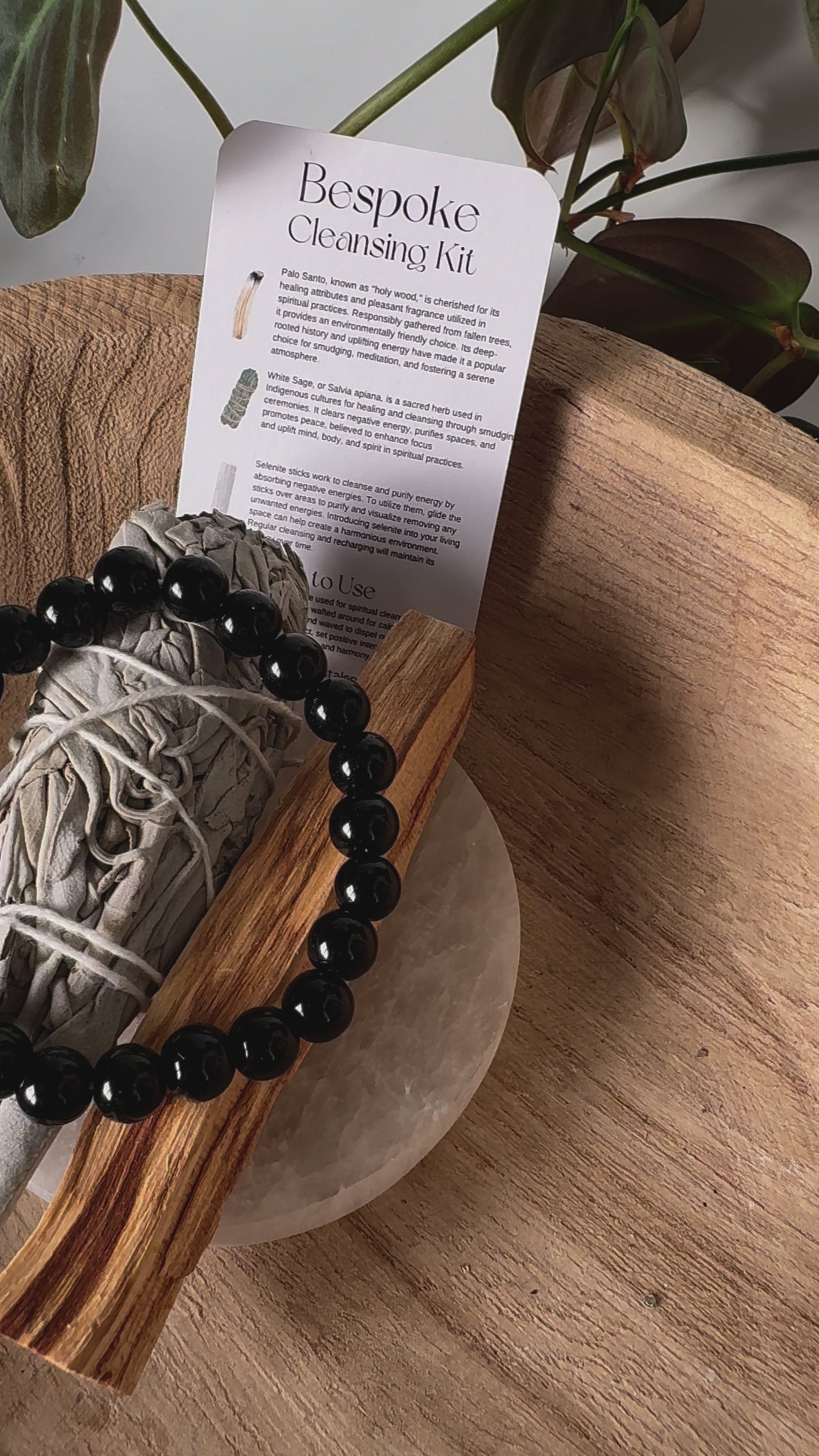 Bespoke Crystal Cleansing Kit with sage, Palo Santo, and black crystal bracelet on selenite plate, perfect for removing negative energy from crystals.
