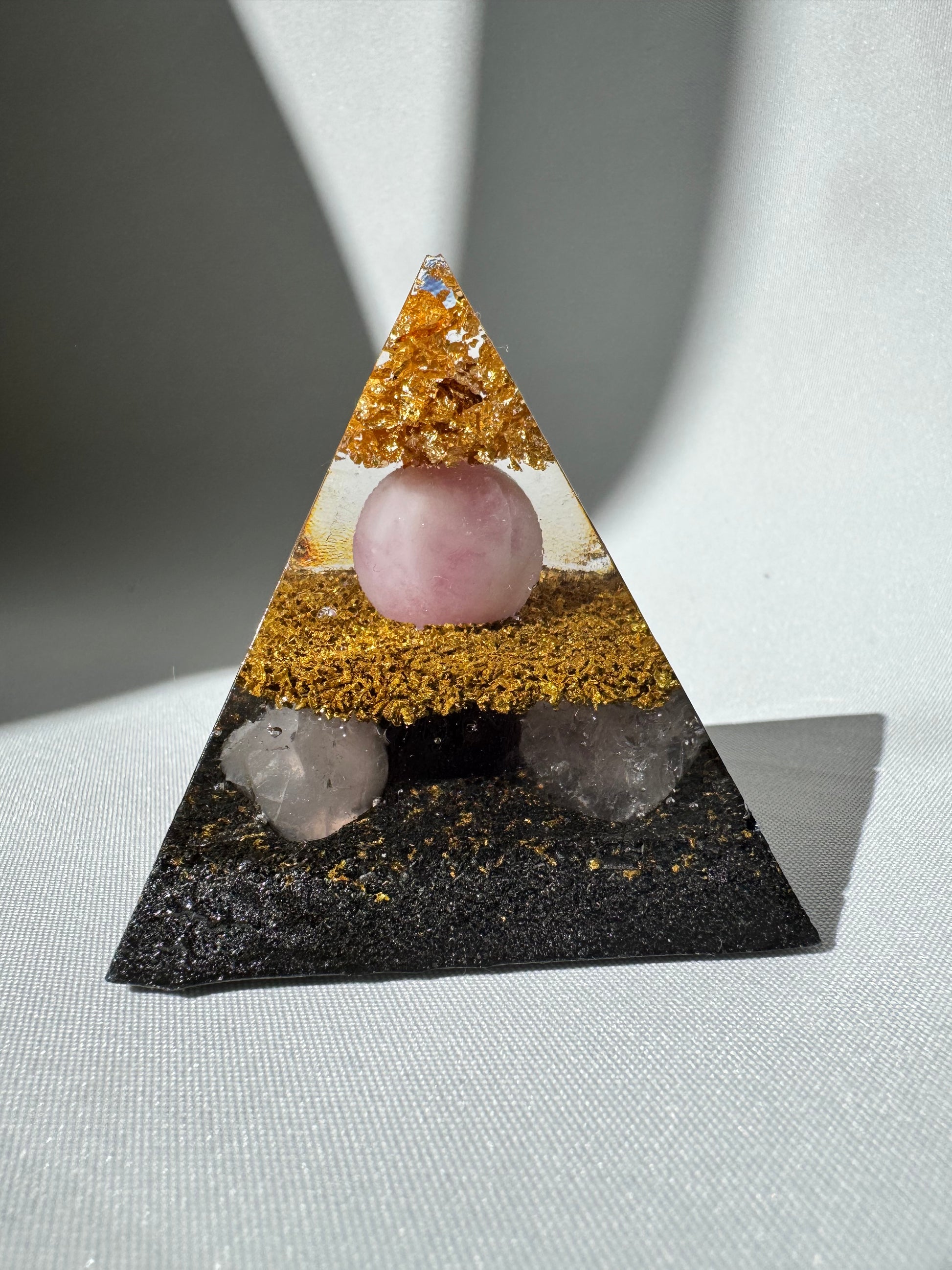Decorative Orgonite pyramid with pink and clear crystals and gold accents
