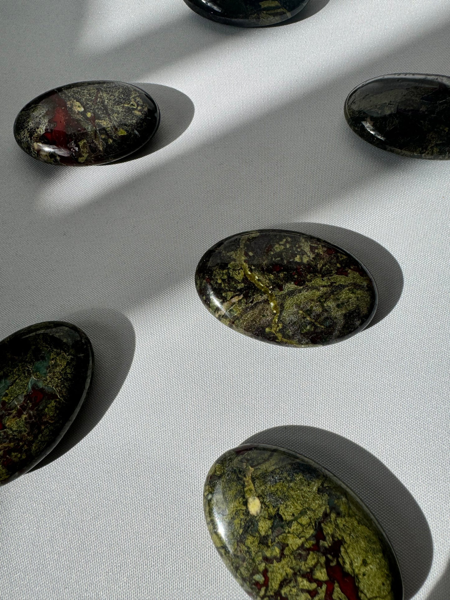 Multiple Dragon Stone Crystal Palm Stones featuring deep earthy tones and striking patterns, perfect for crystal healing and rock collections.