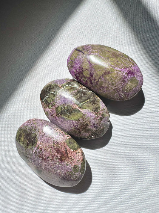 Set of three Atlantisite Crystal Palm Stones with green and purple hues, perfect for collectors and crystal healing enthusiasts.