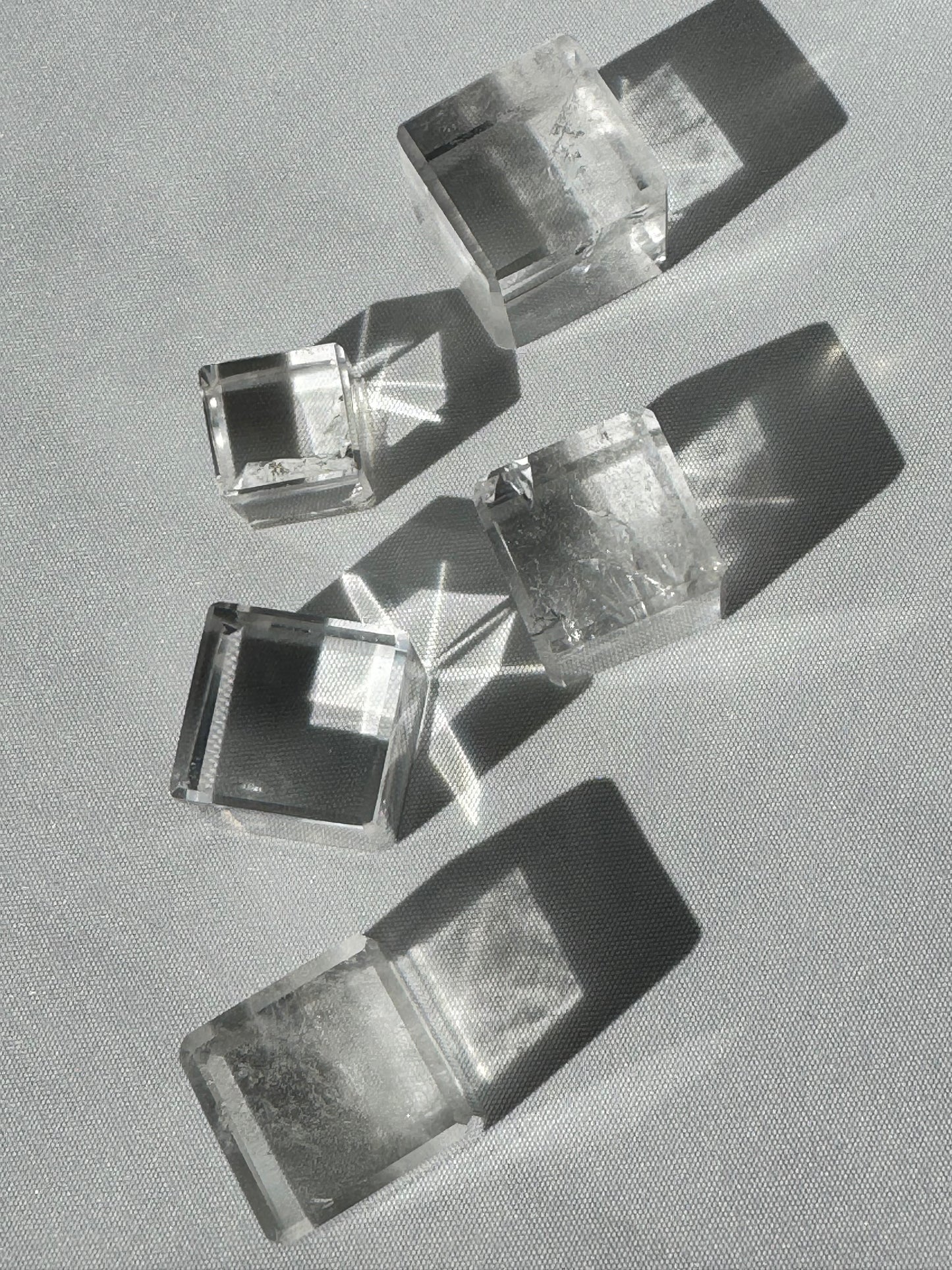 Lemurian Hexahedron Cube 5-piece set arranged in sunlight, highlighting their transparent structure and transformational energy properties.