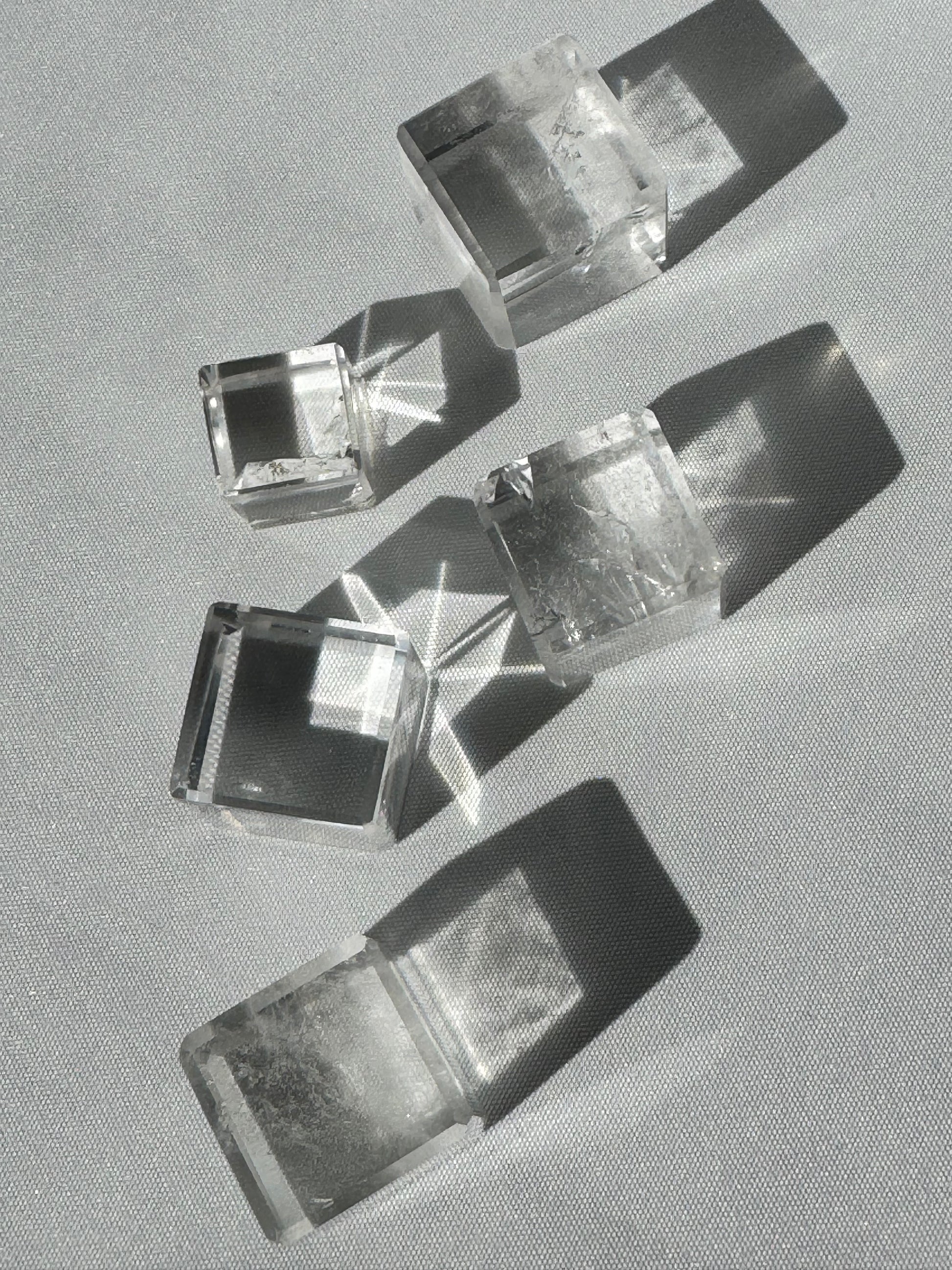 Lemurian Hexahedron Cube 5-piece set arranged in sunlight, highlighting their transparent structure and transformational energy properties.