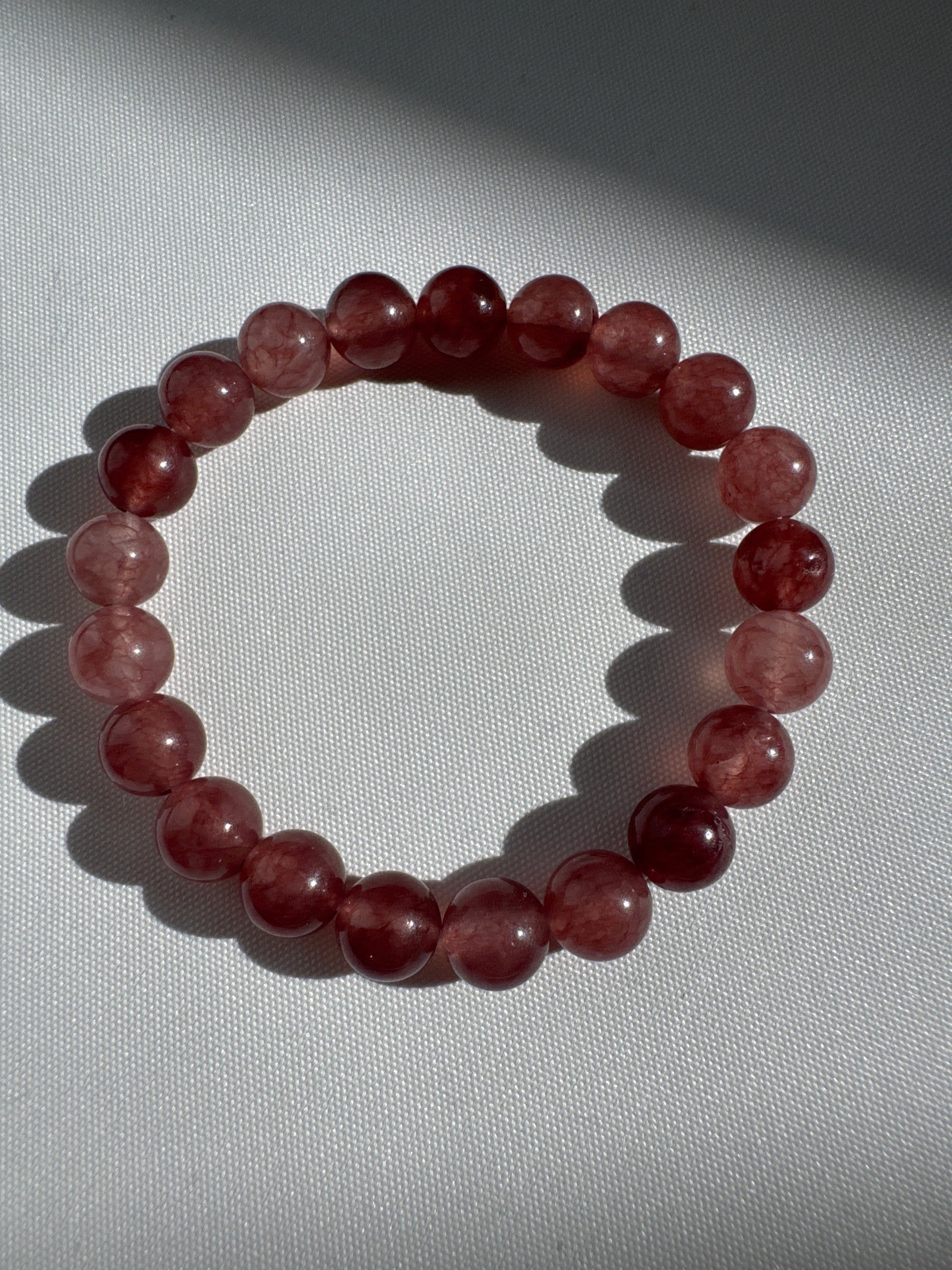 Bespoke Strawberry Quartz Crystal Bracelet featuring polished pink-red beads, perfect for compassionate energy and crystal healing accessories.