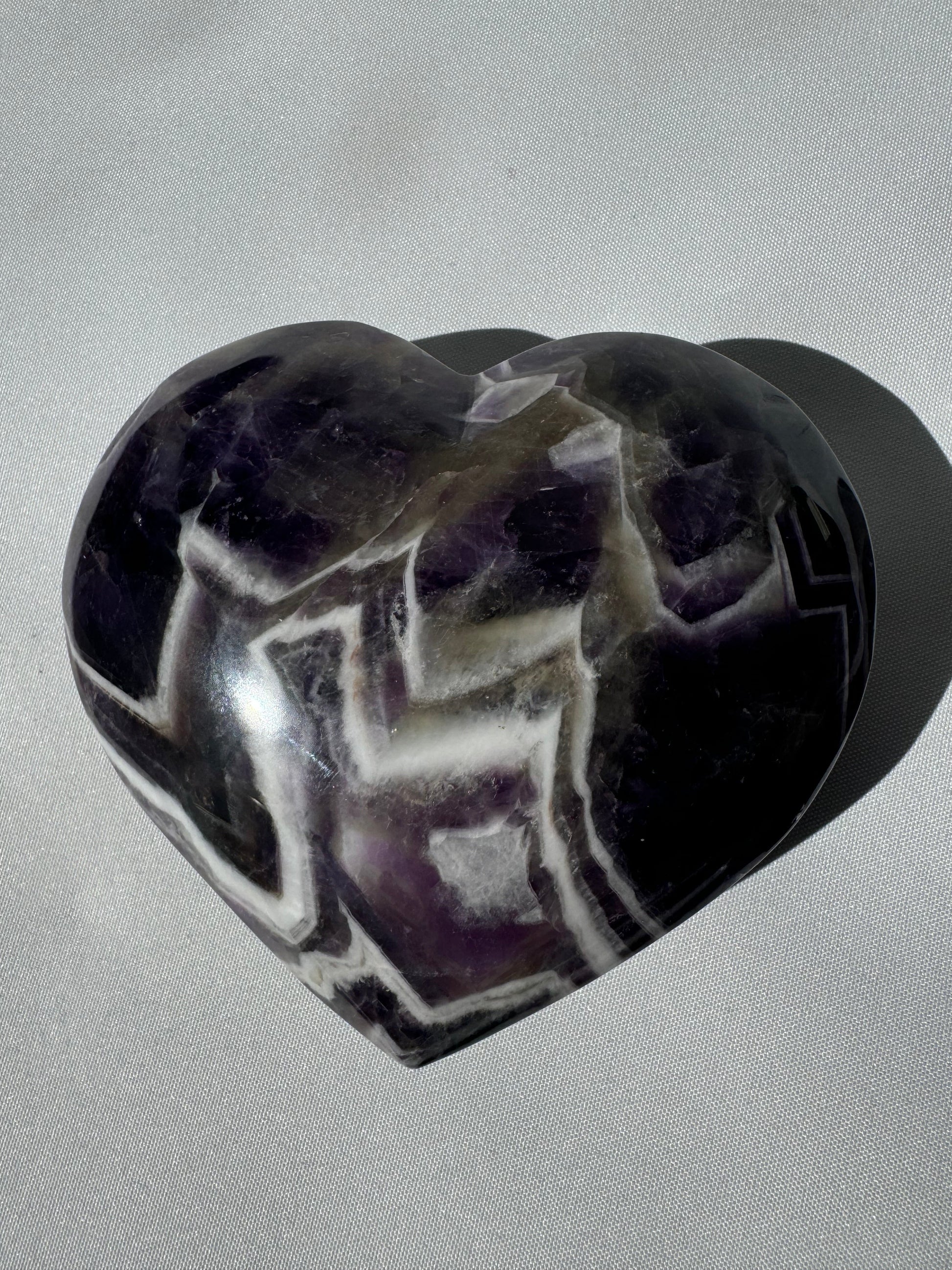 Close-up of Large Chevron Amethyst Crystal Heart highlighting natural zigzag banding, a unique collectible for gemstone enthusiasts.